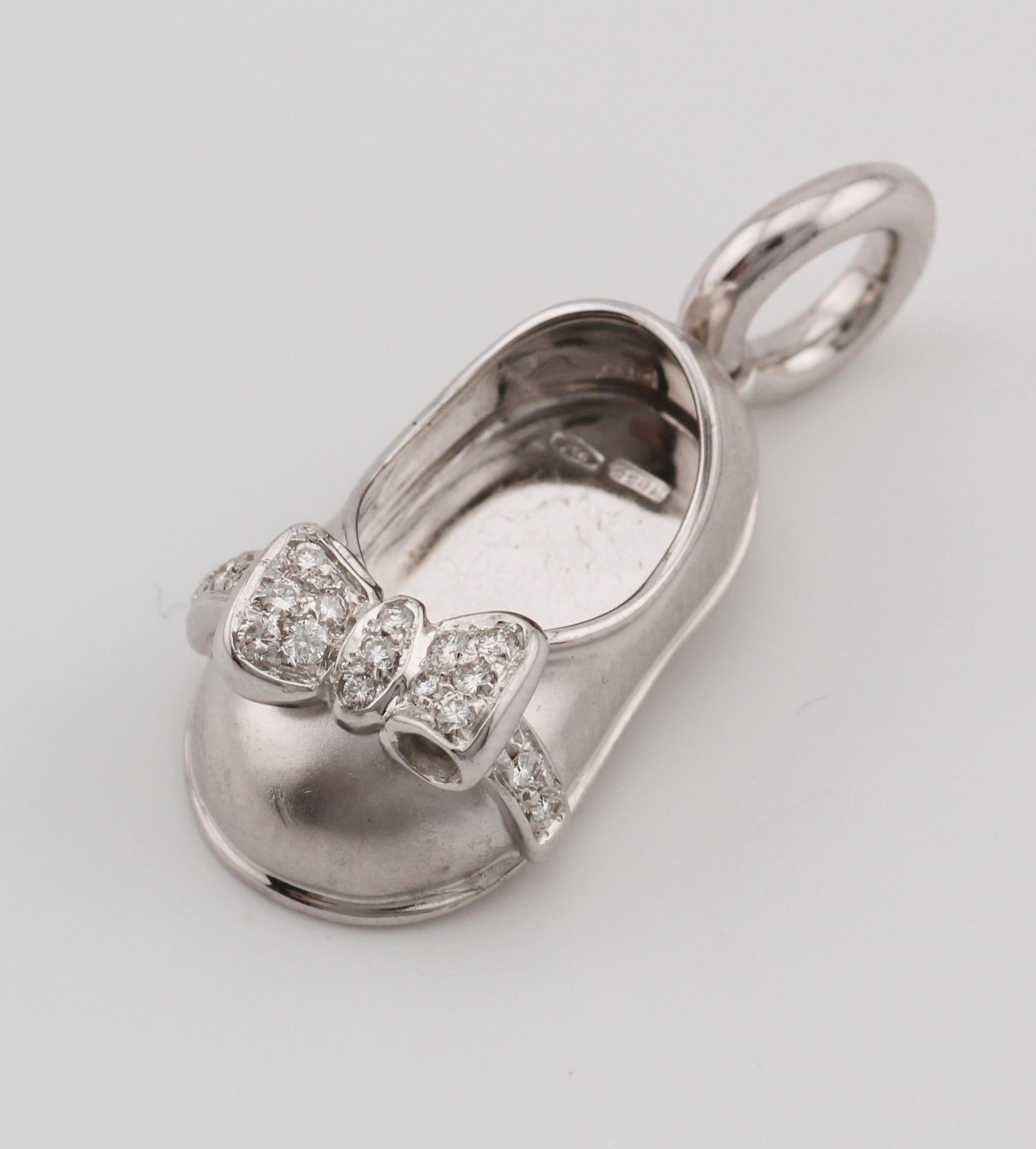 The Aaron Basha Diamond 18K White Gold Baby Girl Shoe Charm Pendant is a delightful piece of fine jewelry that captures the innocence and charm of infancy. Crafted from luxurious 18K white gold, this pendant features meticulous attention to detail,