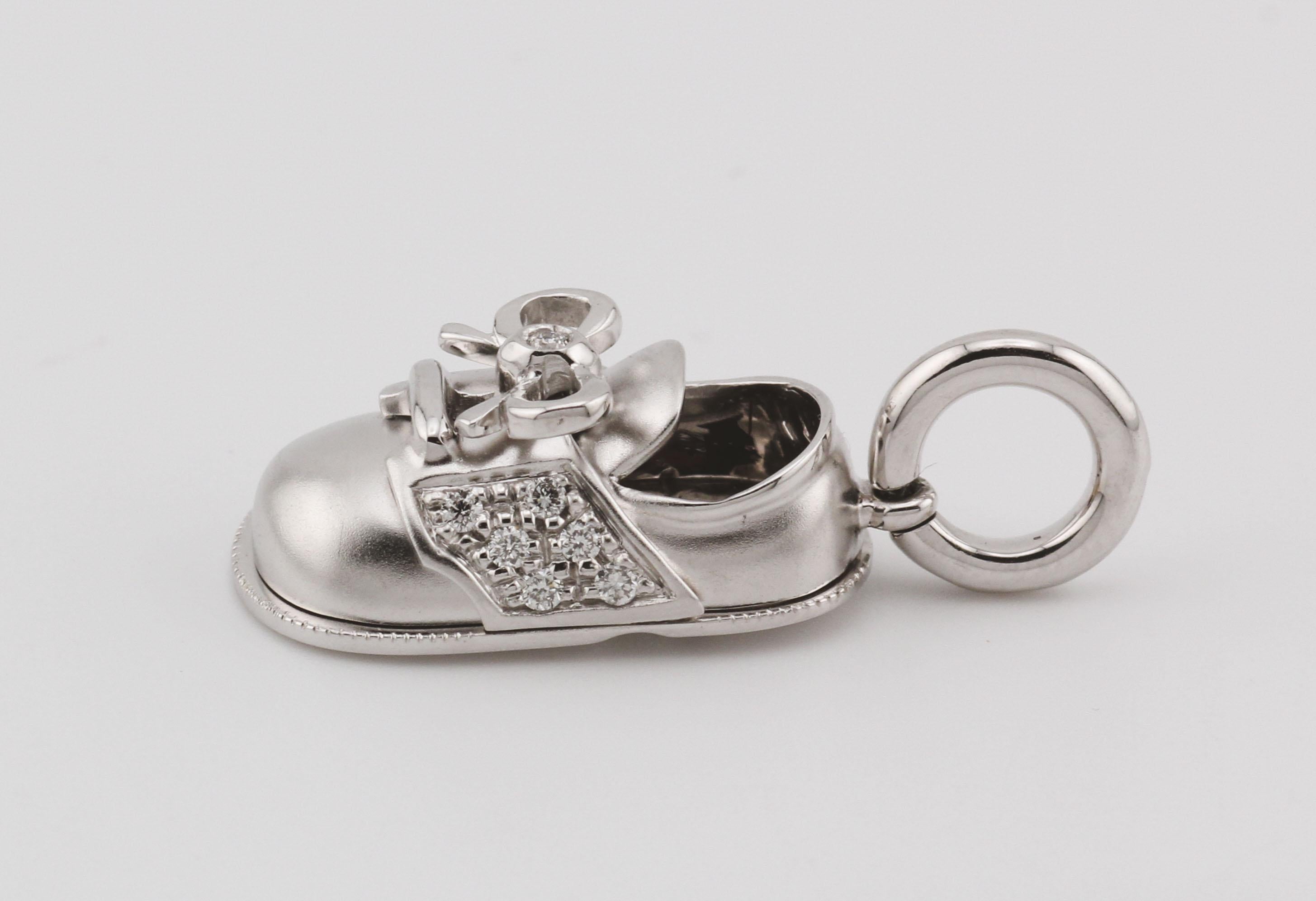 The Aaron Basha Diamond 18K White Gold Baby Boy Shoe with Bow Charm Pendant is a masterpiece of luxury craftsmanship, blending elegance with adorable charm. Crafted from the finest 18K white gold, this pendant captures the timeless beauty of