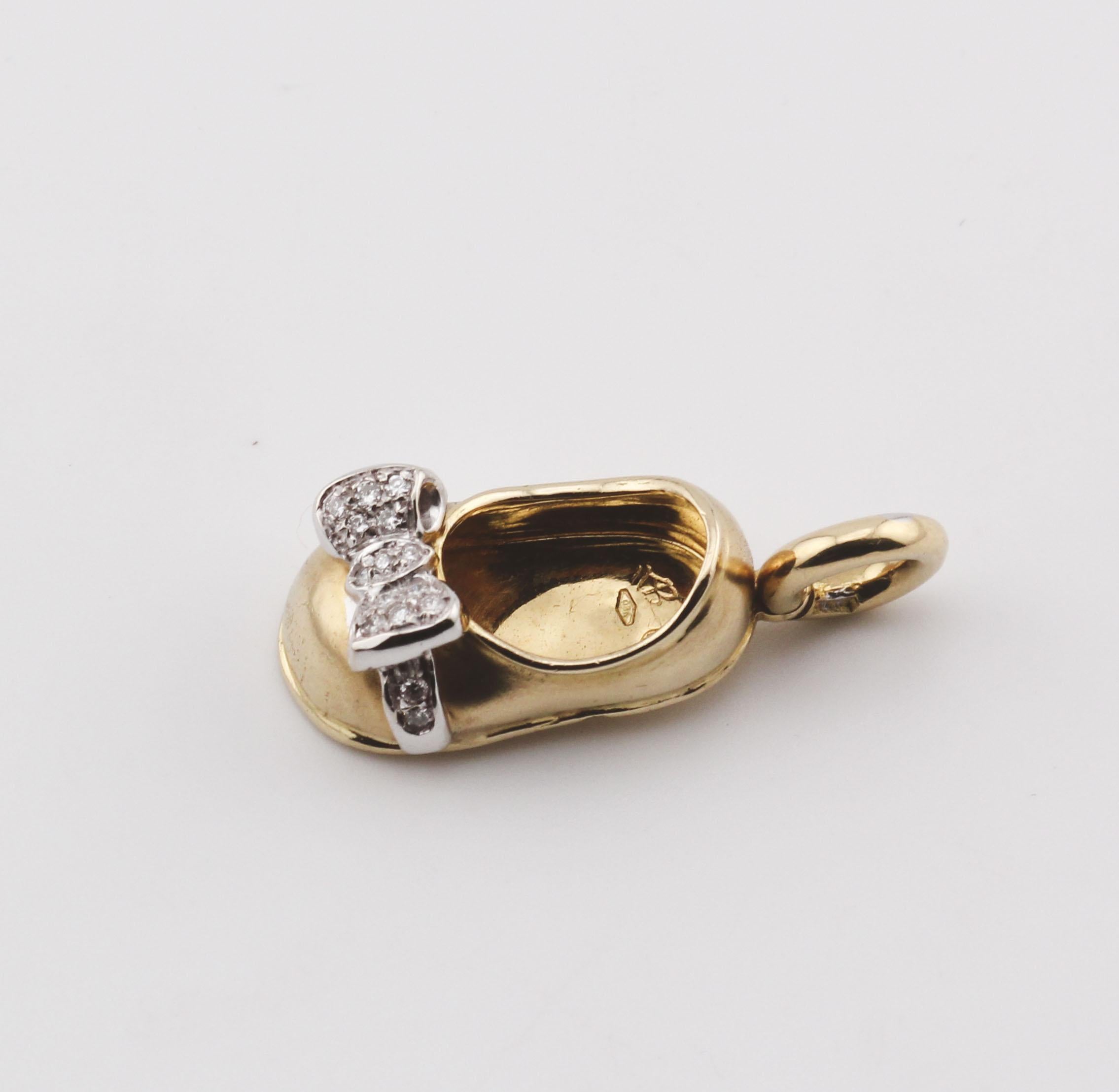 The Aaron Basha Diamond 18K Yellow and White Gold Baby Girl Shoe Charm Pendant is a delightful piece of fine jewelry that captures the innocence and charm of infancy. Crafted from luxurious combination of 18K white and yellow gold, this pendant