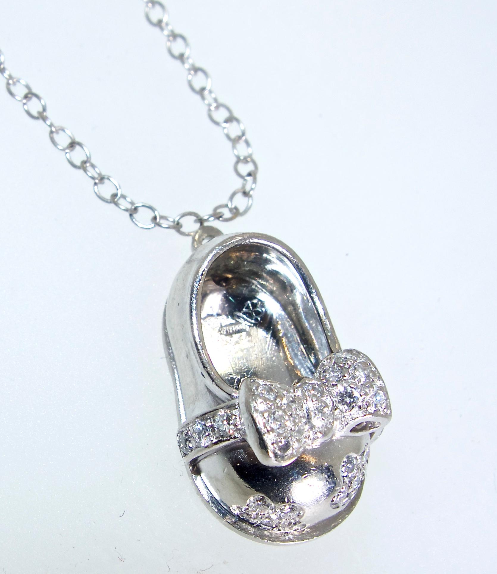 Baby shoe pendant with diamonds in platinum, this pendant on a white gold chain is one inch by one-half inch.  The delicate diamonds are all H/VS1.  New condition by Aaron Basha.