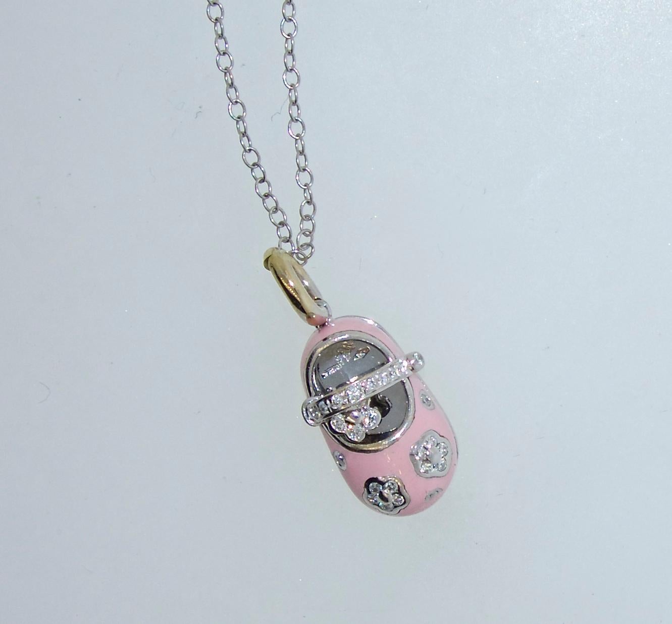 New condition, probably not worn, this pendant on a white gold chain is pink enamel and decorated with white (H,VS1) diamonds, the baby shoe is one inch by .5 inches.
