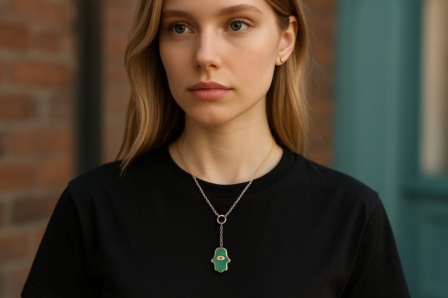 Uno squisito emblema di protezione e stile vivace

Goditi la spensierata raffinatezza di Aaron Basha con questo ciondolo Hamsa in Basha Gold 18 carati, ornato da uno smalto turchese e da un brillante occhio di diamante. Abbinato a una catena d'oro