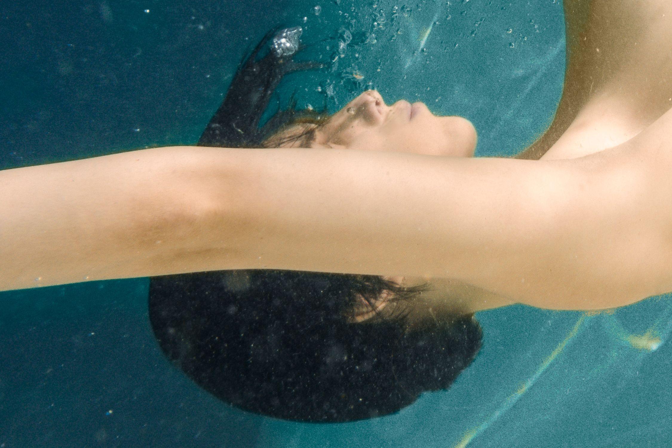 From a limited edition of 5 archival photographs.   Signed and numbered by artist Aaron Knight.   In this underwater nude artwork, a slender female figure plummets into cerulean waters.   Art-ID: PS3_MG_0102    Considerations:  This image is a