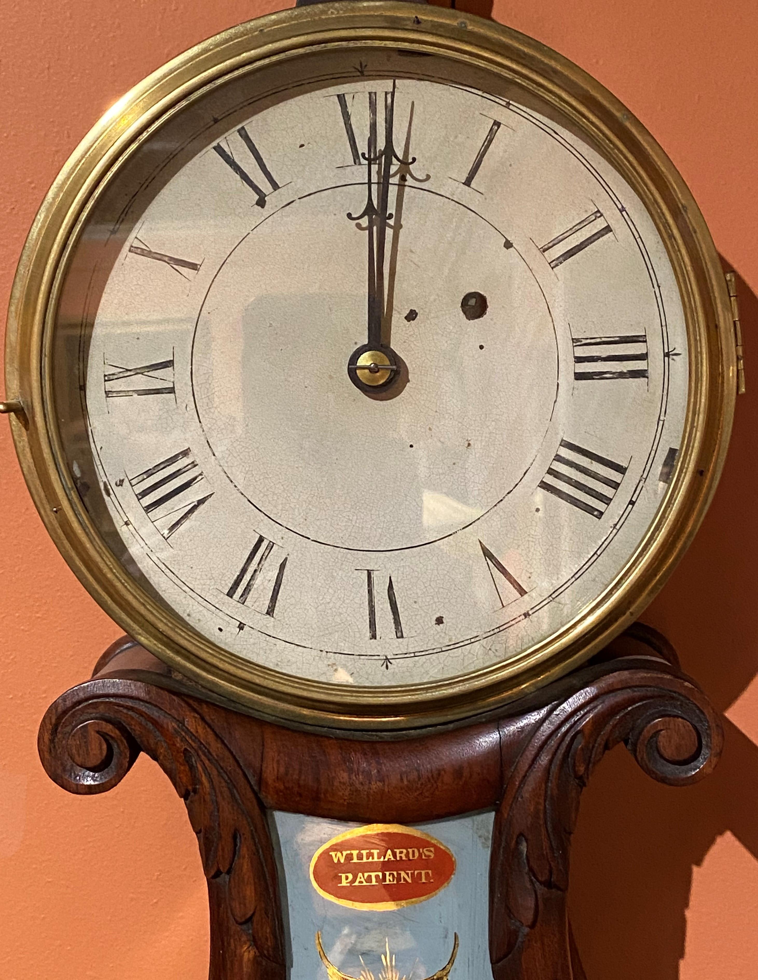 A fine Willard’s Patent lyre form wall clock in carved mahogany case by Aaron Willard (1757-1844) with carved foliate finial, 7 inch Roman numeral hand painted dial, original reverse painted glass throat panel featuring two battling tall ships,