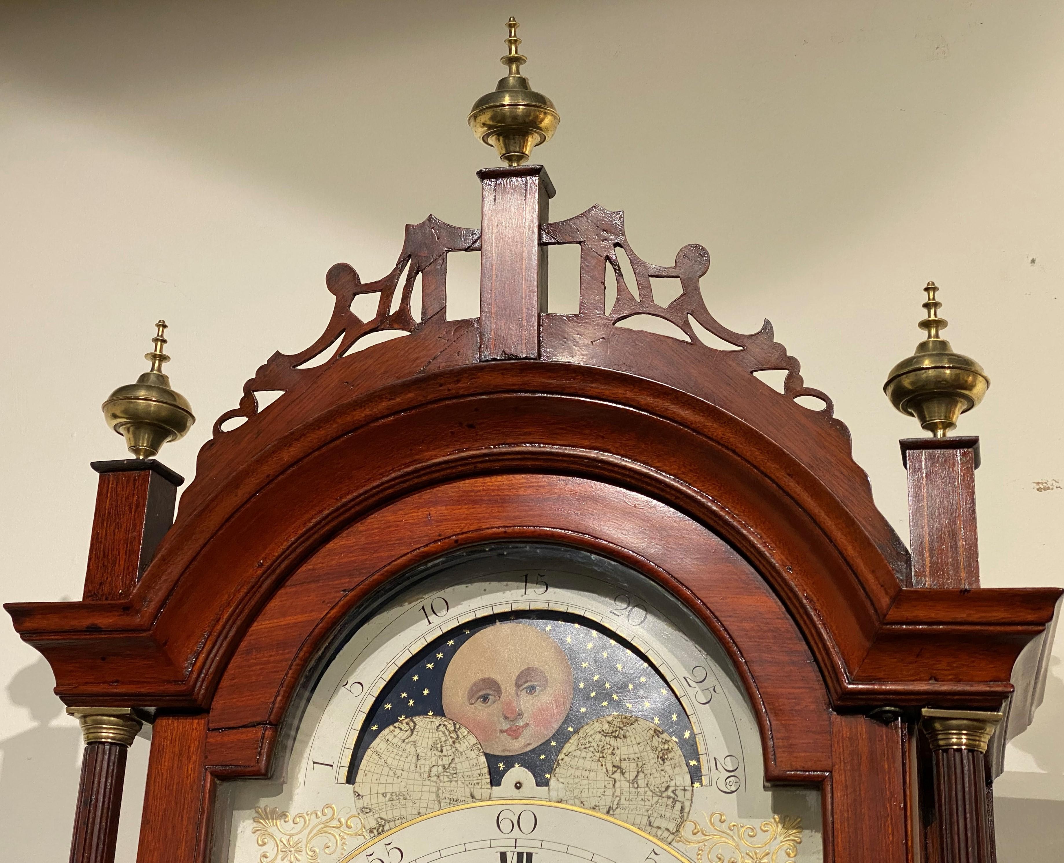 A fine mahogany tall case clock with wonderful proportions by Aaron Willard (1757-1844), with a reticulated carved crest with three ball and spire finials surmounting an arched glass hood door, opening to a hand painted metal Roman numeral dial,