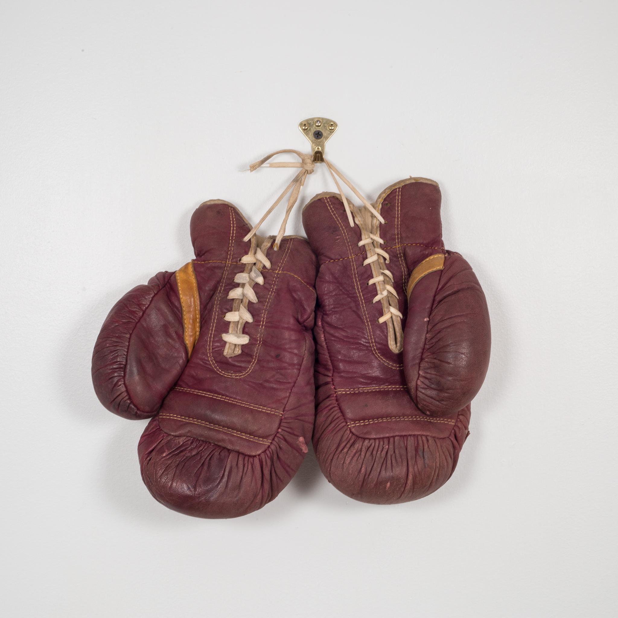 About

This is a original pair of vintage boxing gloves. The gloves are a maroon leather and and tan leather on the palm with white laces. The are both marked 