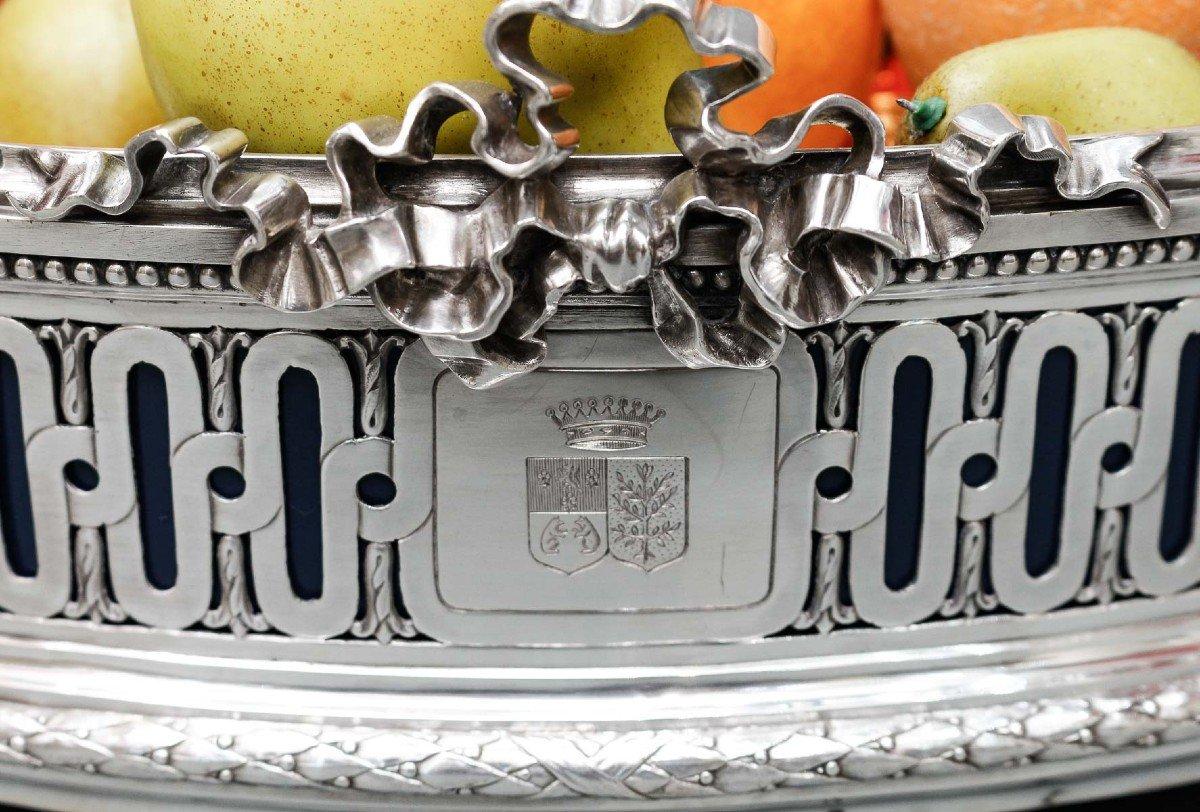 Solid silver planter, oval LOUIS XVI style model, mounted on four straight legs, the body openwork with ribbed warheads, staples and oves, engraved with a coat of arms surmounted by a count's crown. The handles are ram's heads. The sheet metal
