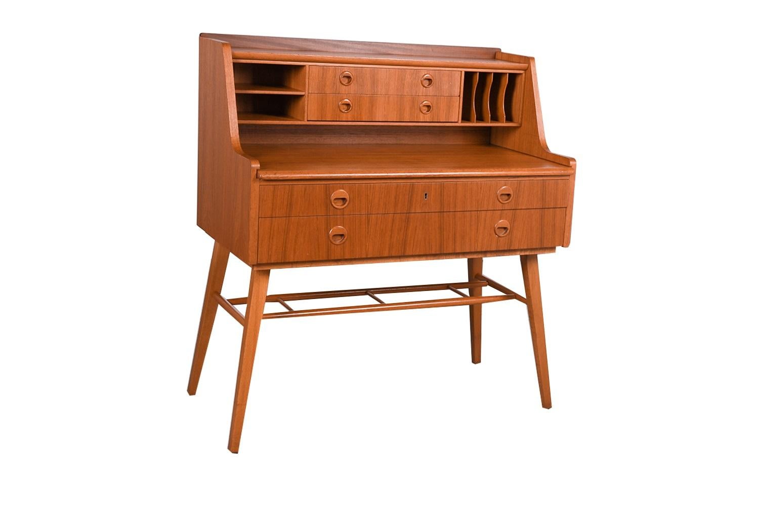 Classic 1960s Mid-Century Modern Scandinavian designed teak secretary desk by AB Bröderna Gustafssons, Sweden. The beautifully shaped contemporary secretary desk is wrapped in a stunning teak veneer featuring upper and lower storage. Two large