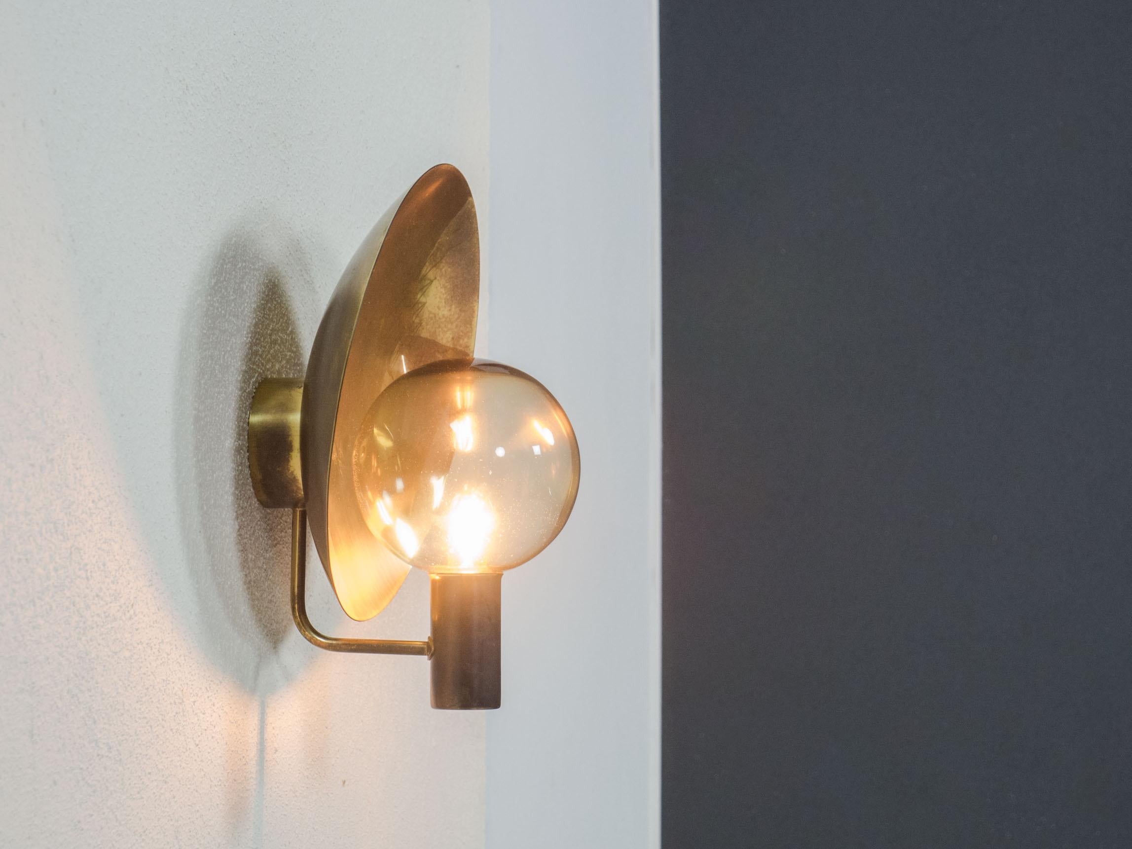 Rare wall sconce designed by the famous Hans-Agne Jakobsson for AB Markaryd of Sweden in the 1960s.

This lamp is made of brass and a thin smoked glass shade.

The lamp is in very good condition, the brass is patinated all around and gives this lamp