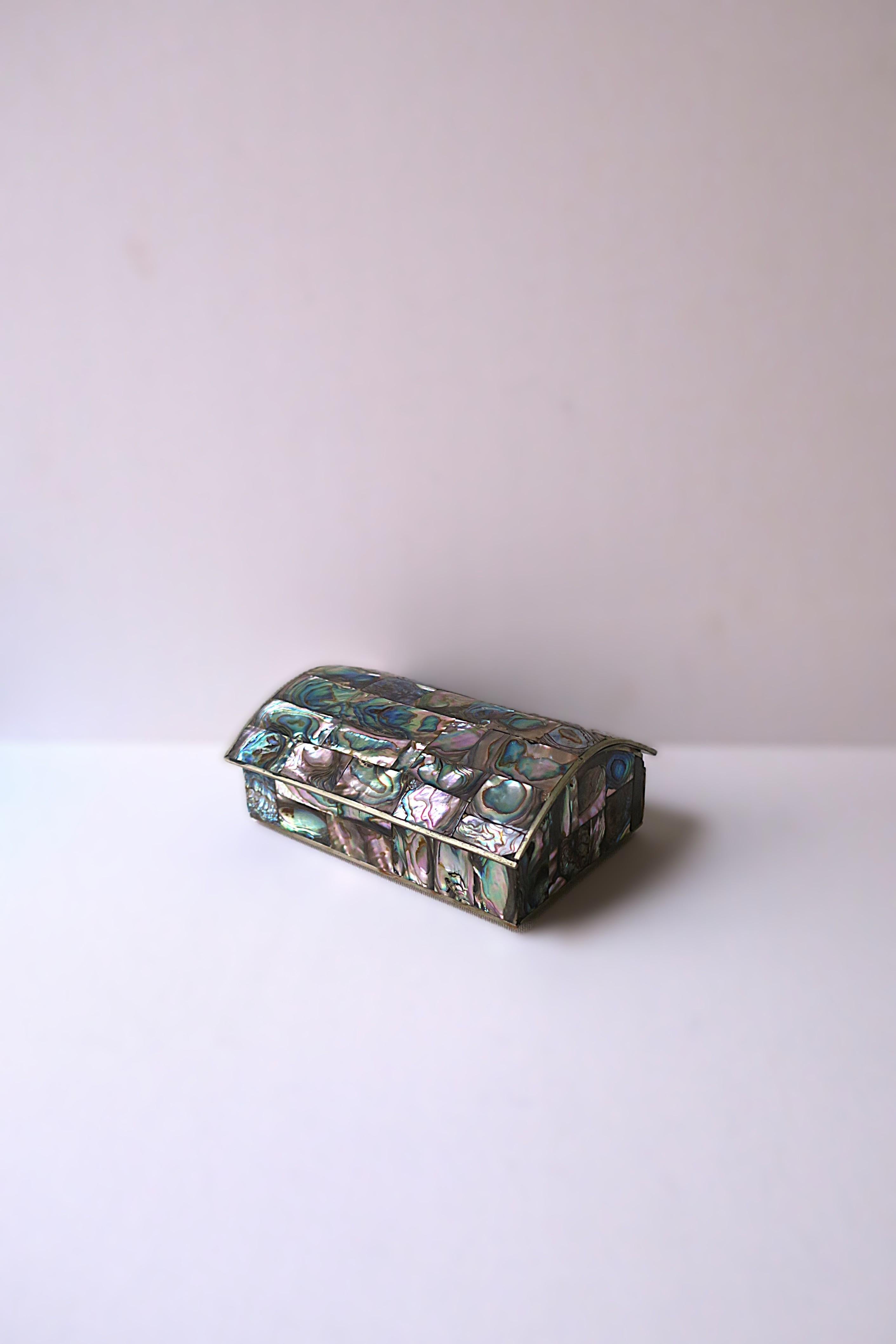 A beautiful abalone seashell box with demi-lune arched lid, circa mid-20th century, 1960s, Mexico. Box is rectangular, entirely decorated with abalone seashell, wood lined, finished with a metal frame and small bun feet. A great decorative or