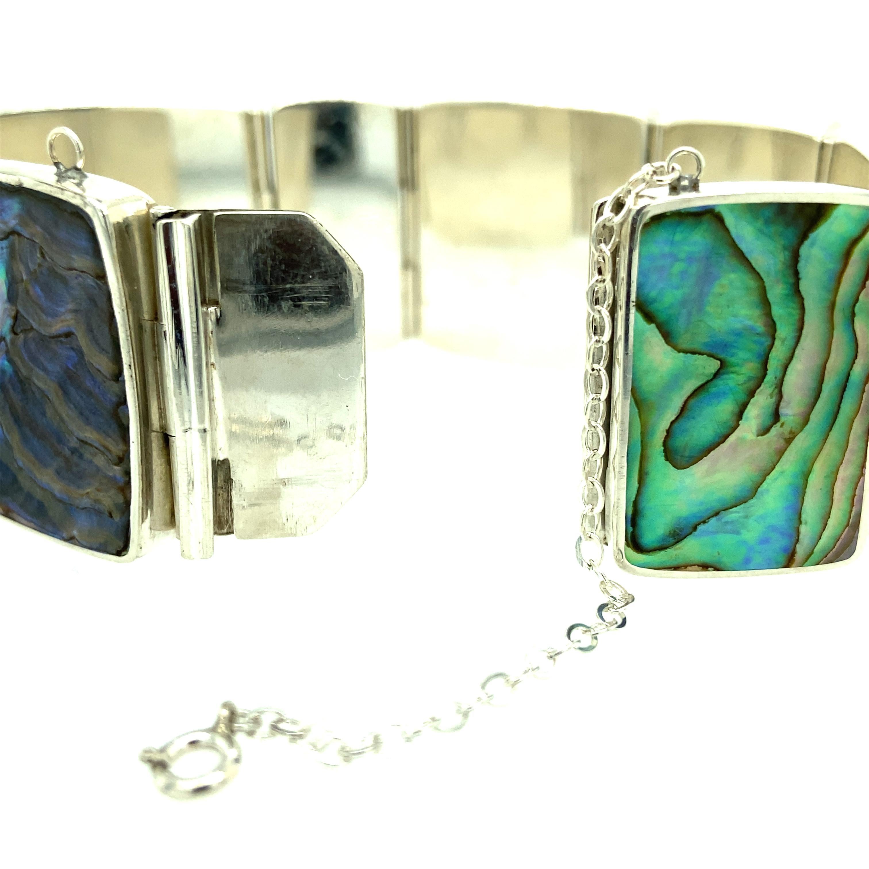 One sterling silver (stamped P. Bis STERLING DENMARK HANDMADE) handmade abalone shell bracelet measuring 7 inches long and a little over an inch wide.  The bracelet is complete with a hidden closure and safety chain. Circa 1970s.