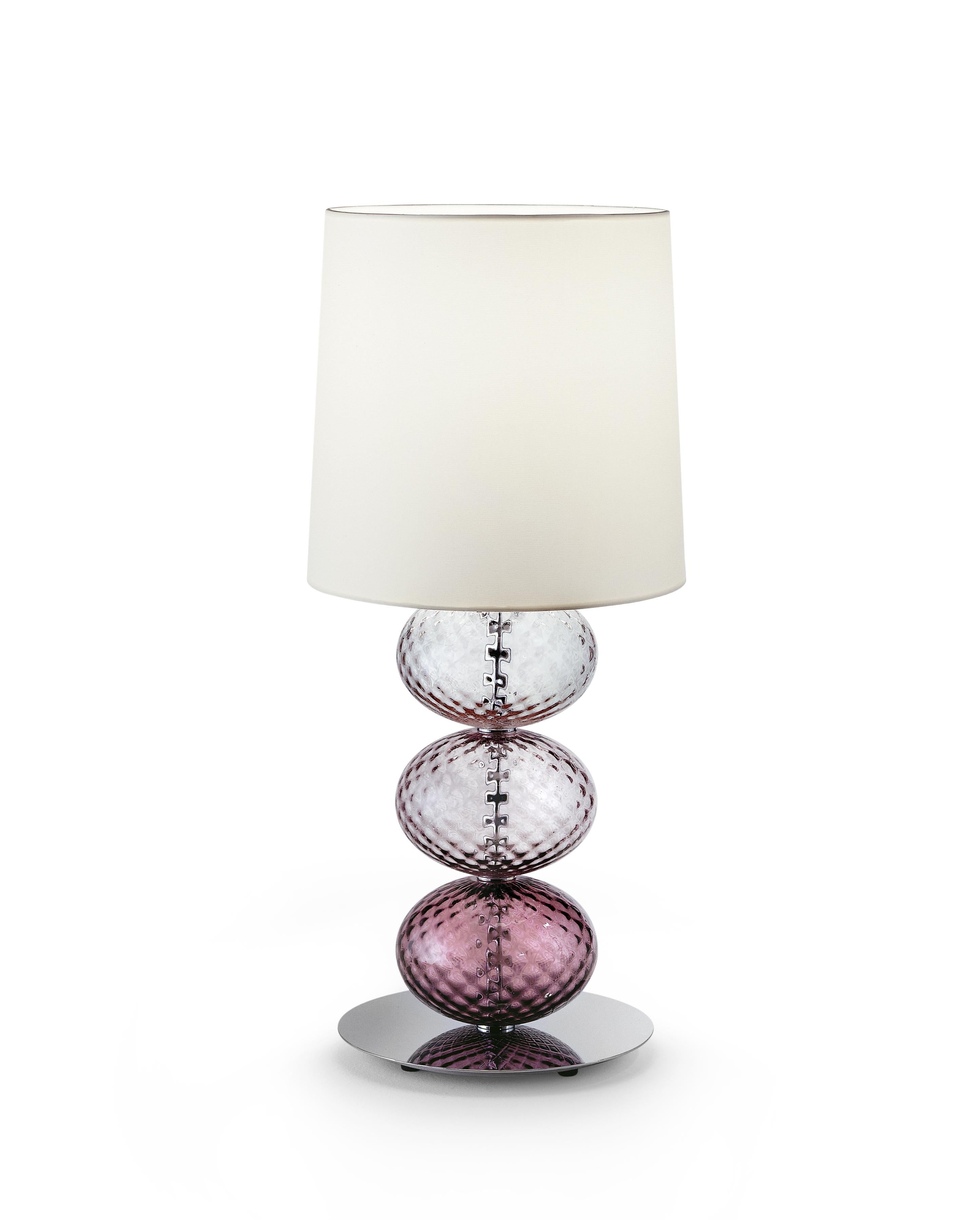 Abat Jour table lamp with white fabric shade, chromium-plated stand and hand-made blown glass elliptical elements. Its combination of white and color make it a subtle yet playful addition to any room. Also available in other colors and as a floor
