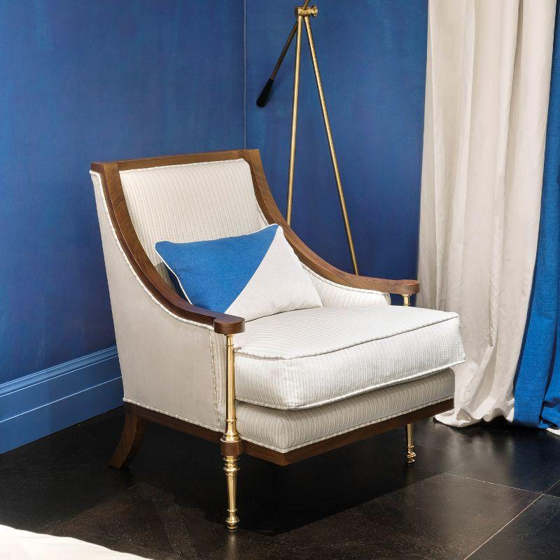 Un suntuoso sillón de refinamiento atemporal, este lujoso diseño será un acento singular tanto en decoraciones clásicas como modernas. Hecho a mano con madera de nogal Canaletto y enriquecido con detalles de latón pulido, está tapizado con elegante
