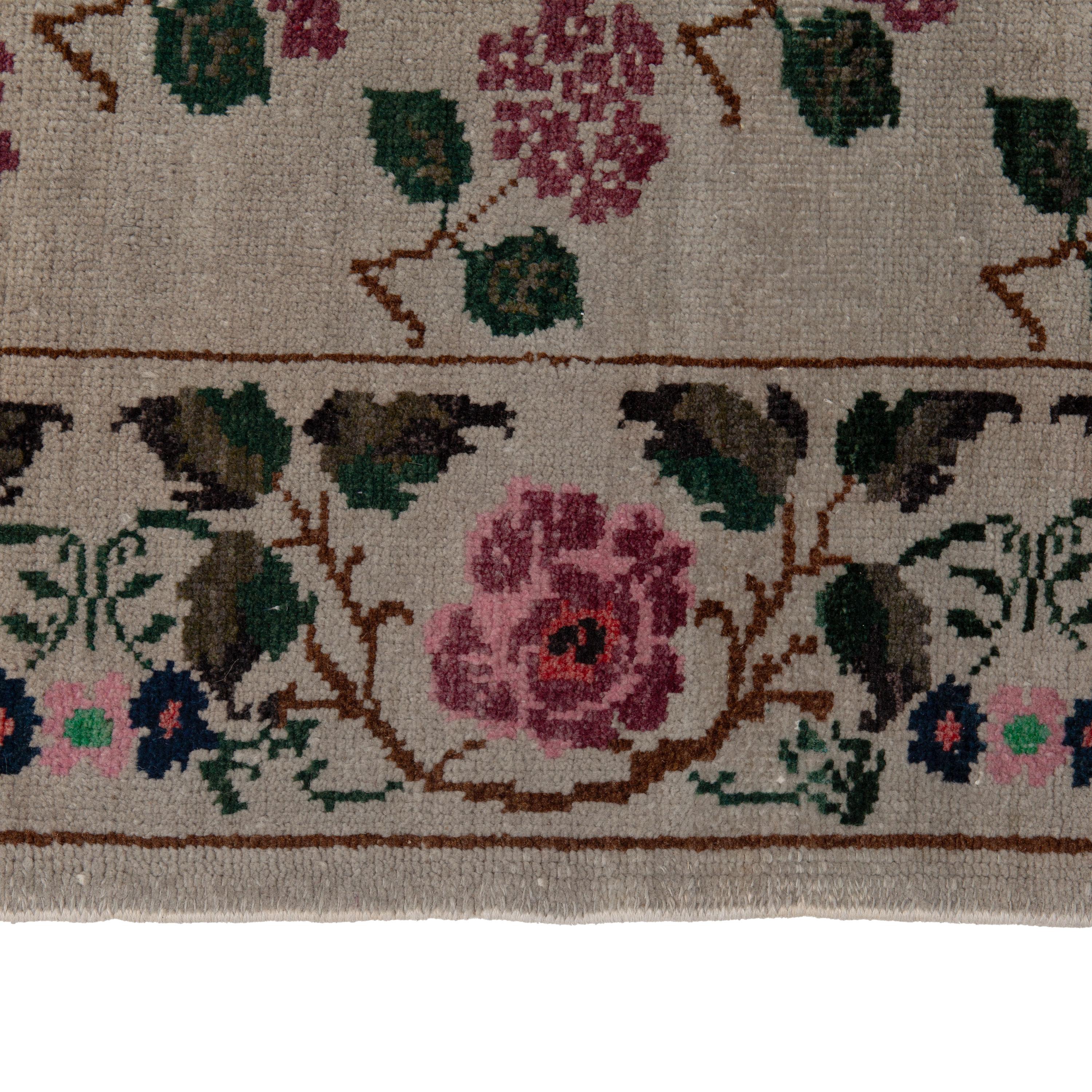Questo tappeto turco vintage tessuto a mano in lana offre un dinamico motivo floreale con autentici motivi anatolici in uno spettro di tinte vegetali. I colori naturali di questo tappeto centrotavola vintage sono sbiaditi dal tempo in sognanti