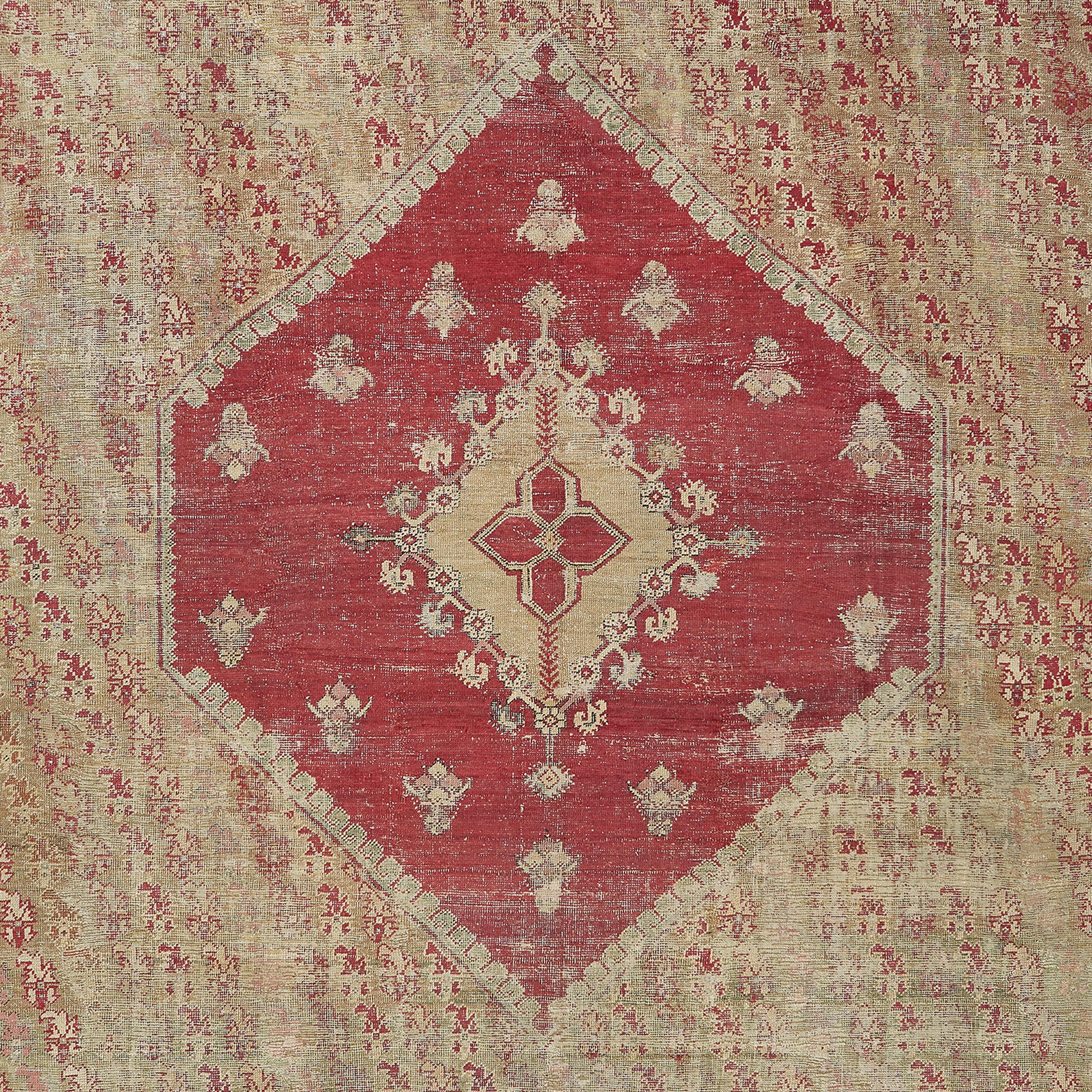 This handwoven wool rug displays a simple crimson medallion that interrupts a profusion of boteh motifs spanning across the soft beige ground. The broken charcoal outlines bring subtle clarity to the overall composition. A late 19th century classic