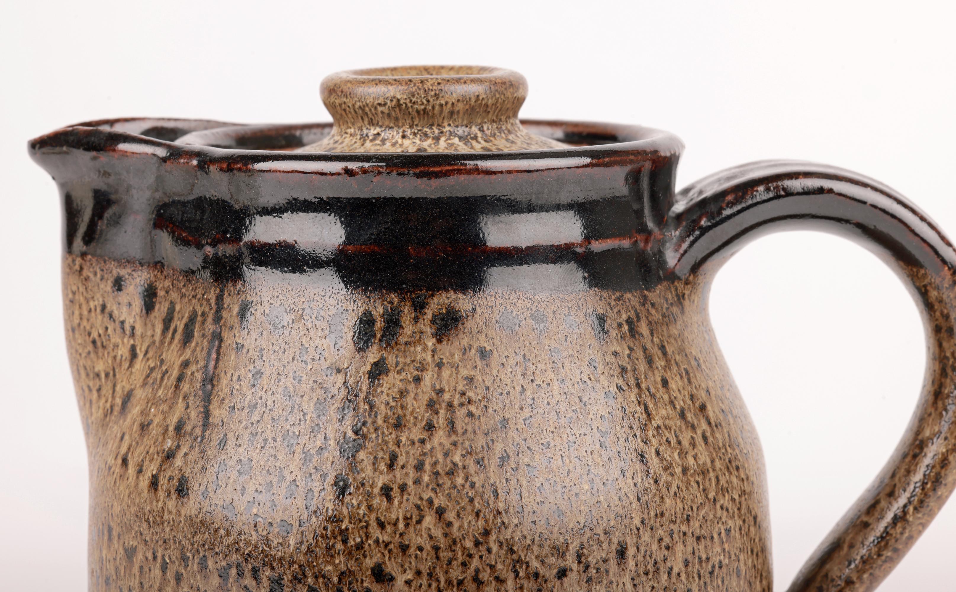 Une superbe cruche et un couvercle en poterie de studio vintage à glaçure avoine tenmoku, réalisés par le célèbre artiste Abdo Nagi (yéméno-britannique, 1941-2001) et datant d'environ 1981. La cruche repose sur une étroite base ronde et plate non