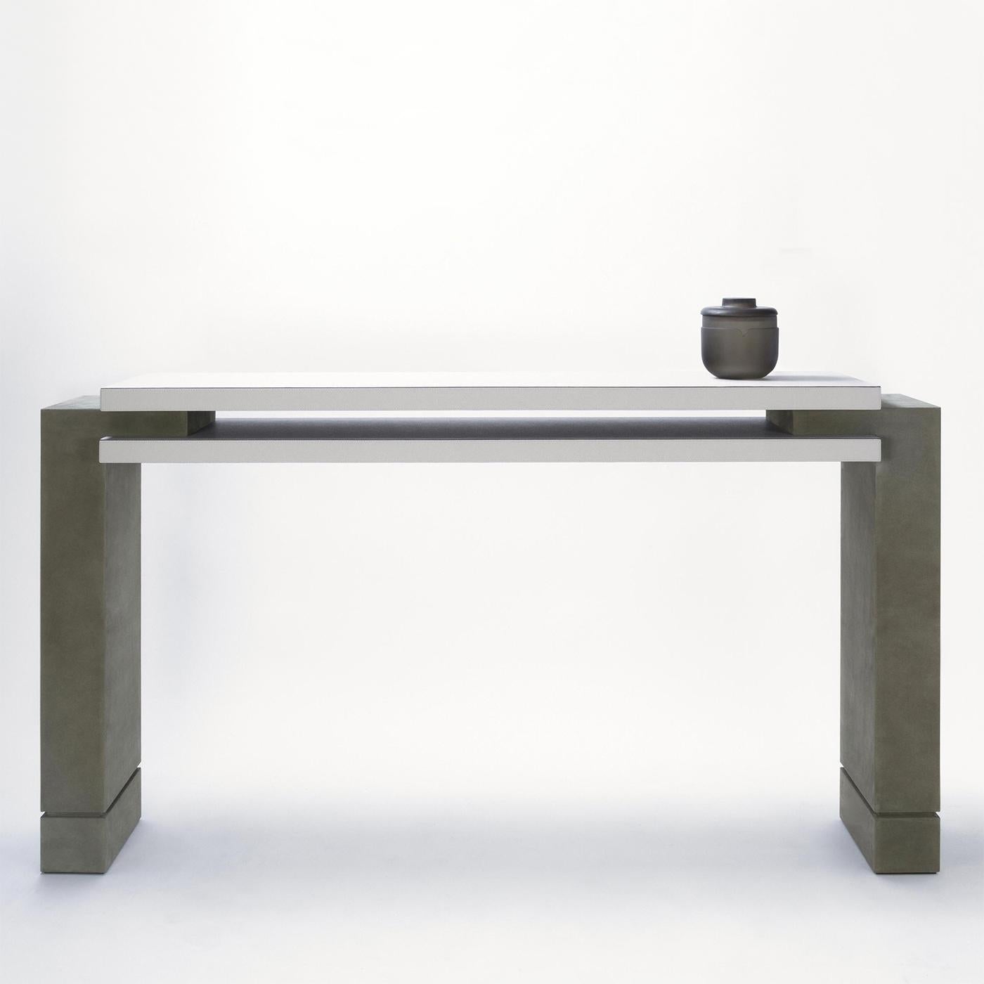 Console Table Abel with structure in solid wood, 
with calfskin genuine leather covered top in white
color and with feet covered with genuine suede 
leather in sober grey color.