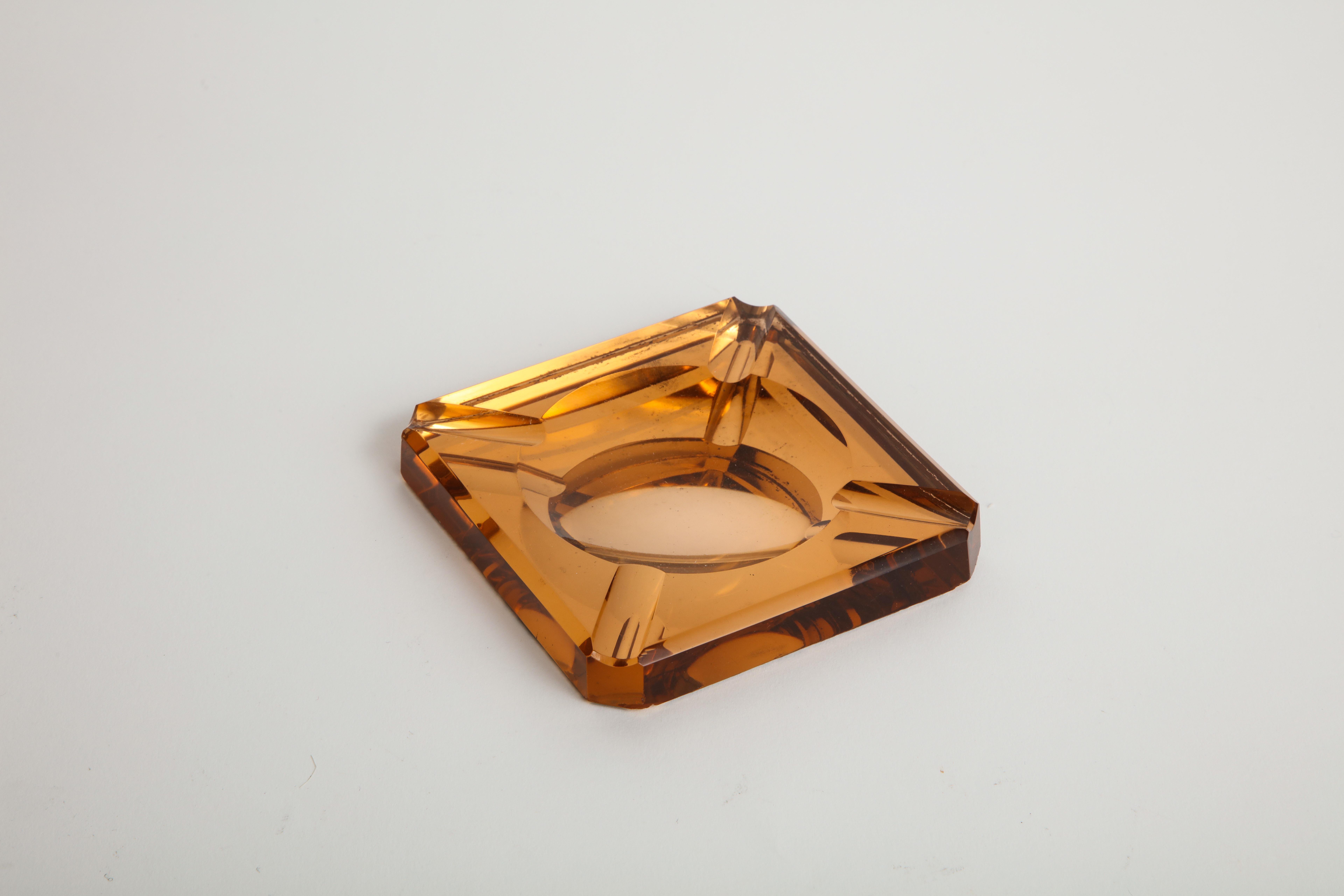 Chic reflective mirrored vintage amber glass catchall, or ashtray that emits an orange-y glow.