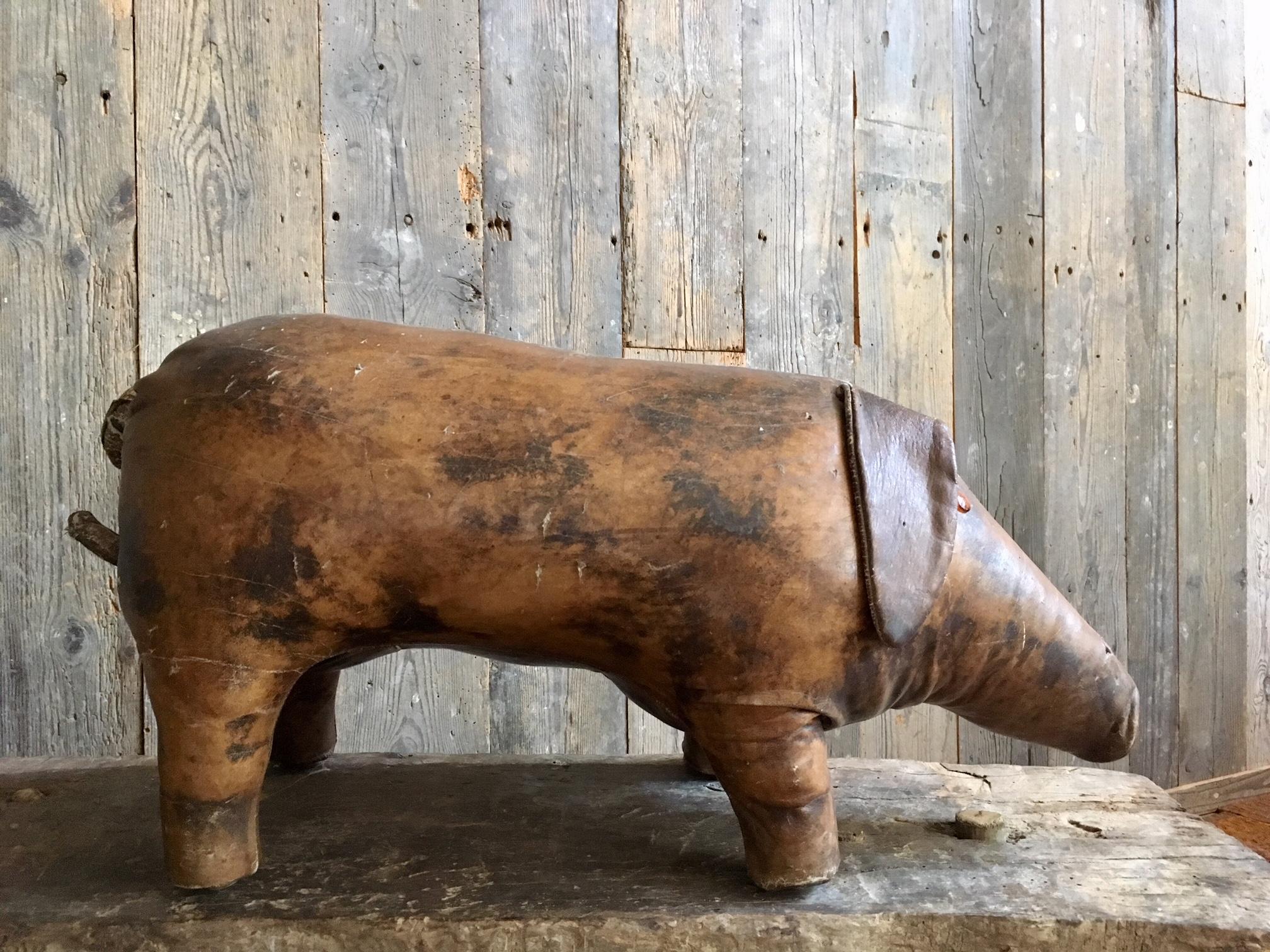 Abercrombie & Fitch vintage leather footstool in the shape of a pig. This footstool is made in the 1960s and the design is by Dimitri Omersa. A special collector's item. The leather shows traces of aging, such as discoloration and small cracks, but