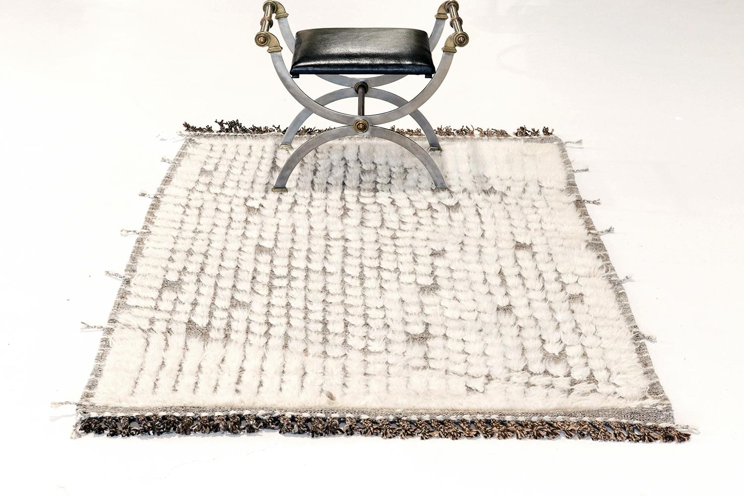 Abisko' is the perfect handwoven rug with embossed detailing and an all over repeating diagonal pattern in white atop a natural gray pile weave. Beautiful tassels and bordered designs add a timely and one of a kind essence. Haute Bohemian