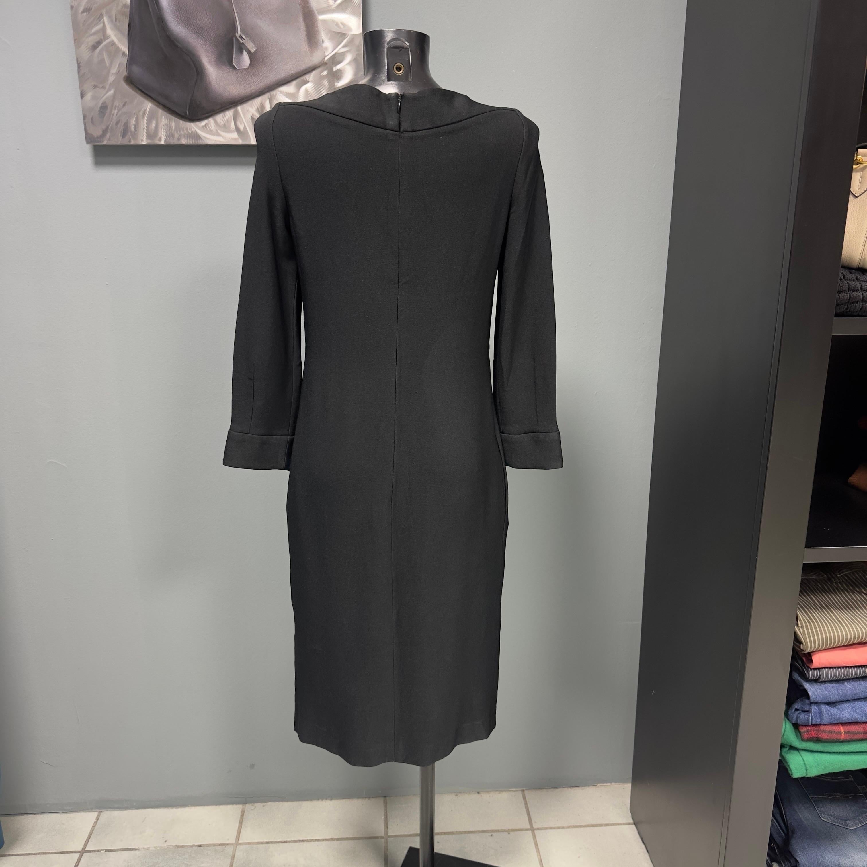 Abito nero Giorgio Armani con scollo a barca e particolare drappeggio sul fronte. Manica lunga, segnata tg 44 ita, vestibilità piccola. Adatto a chi piace essere comoda ed elegante e chi non ama gli abiti che segnano troppo le forme. Dotato di