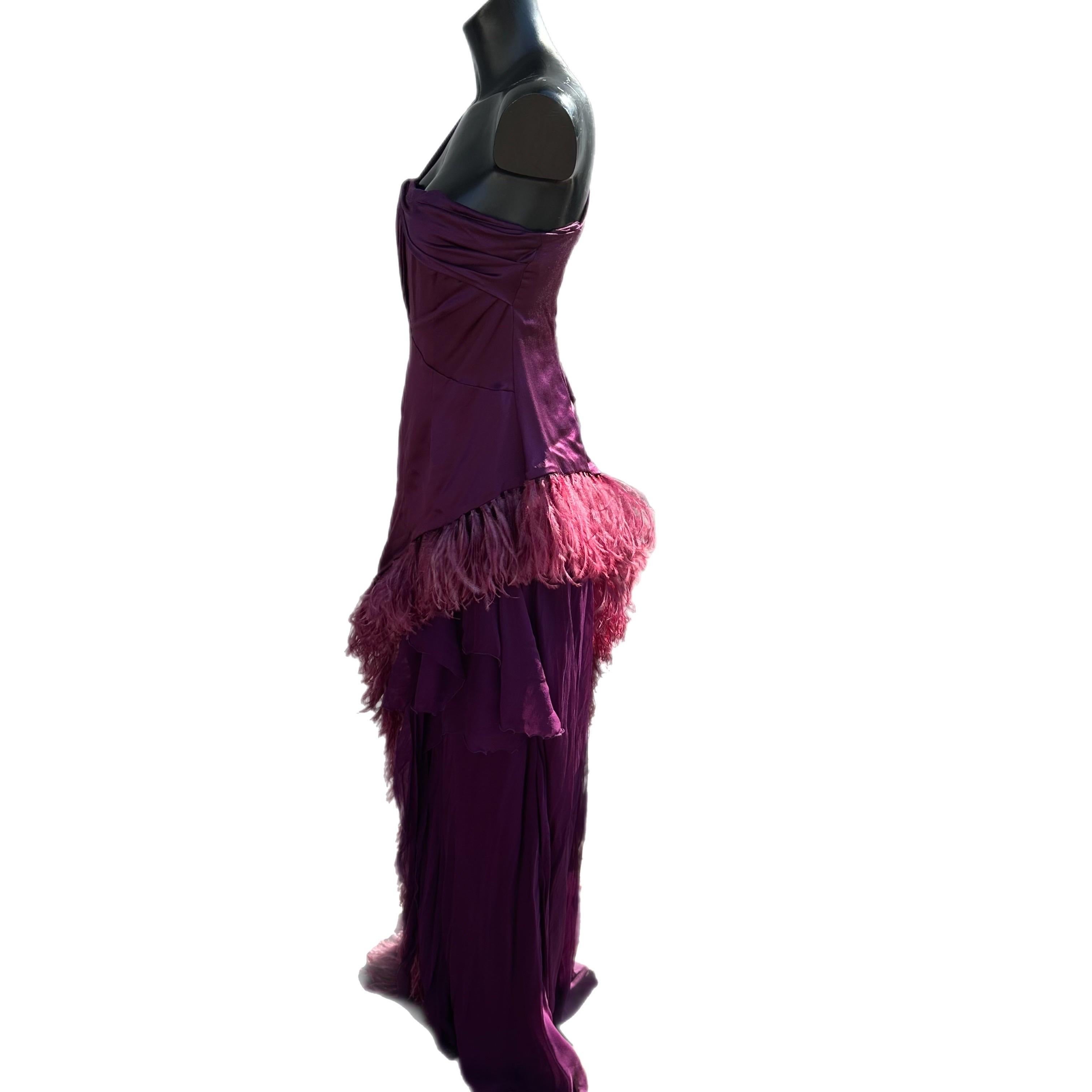 Meraviglioso abito di ricerca vintage anni 50, colo viola
la sua coda leggera rende fluido l'abito che è contornato da pregiate piume.
La parte superiore a bustino è completata da una fascia trasversale ed una bretella della stessa dimensione
