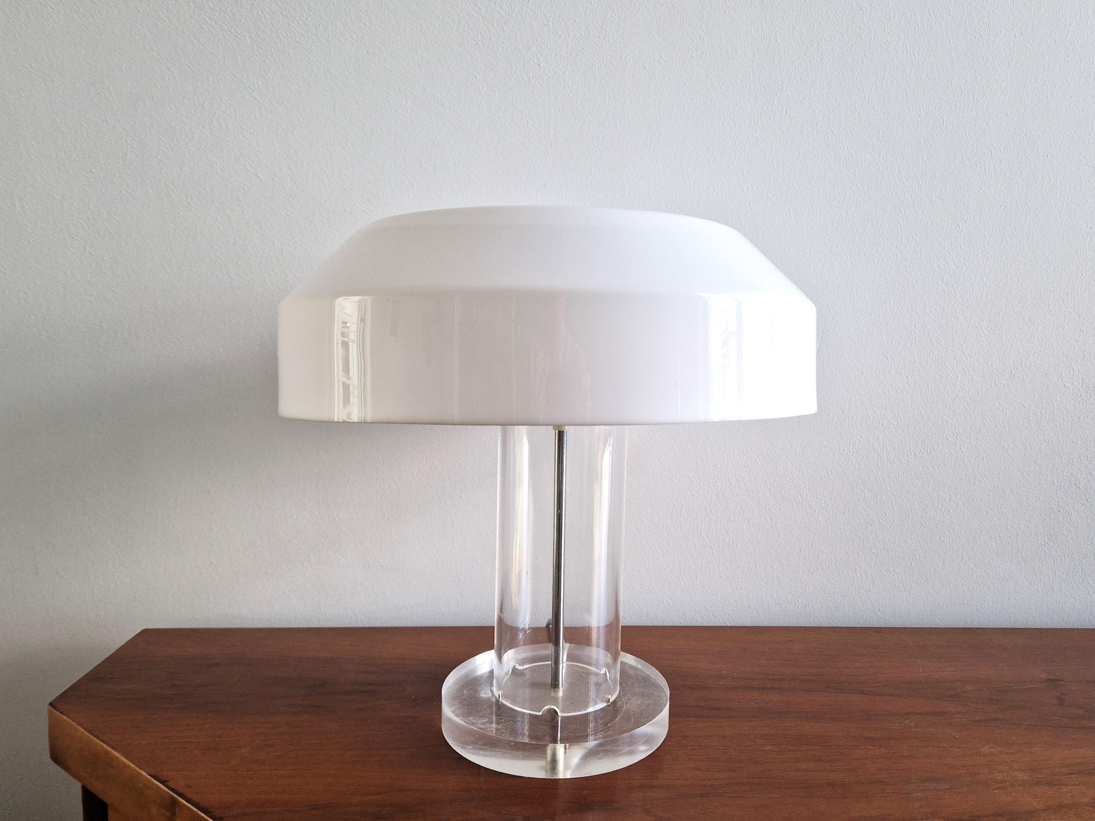 The 'ABN' lamp was commissioned for the ABN AMRO bank around 1975 and produced in a limited edition by Aldo van den Nieuwelaar's own company. The lamp has a white plastic shade that rests directly on a transparent plexiglass base. The light pictured