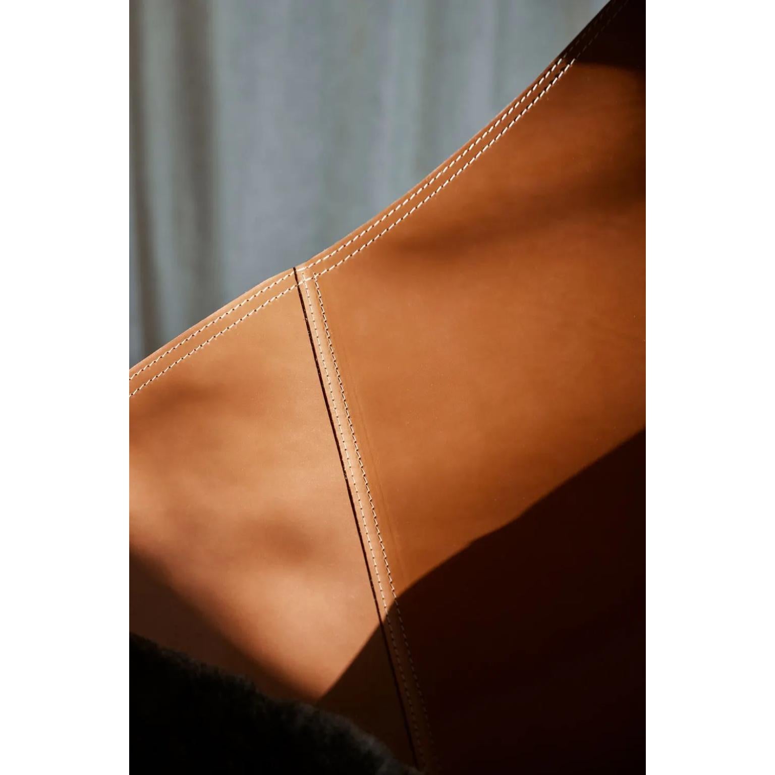 Abrazo Lounge Chair by Cuero Design
Dimensions: D 86 x W 87 x H 92 cm.
Materials: Black leather and metal.
Finish: Crude Nature leather and black frame.
Weight: 12 kg.

Available in different upholstery and metal color options and finishes. Prices
