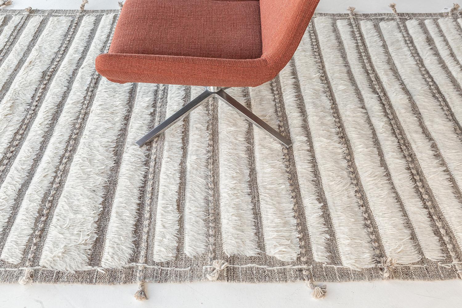 Abrolhos is a handwoven luxurious wool rug with timeless embossed detailing. In addition to its perfect ivory flat-weave, Albrohos has a beautiful shag that brings a lustrous texture and contemporary feel to one's space. The Haute Bohemian
