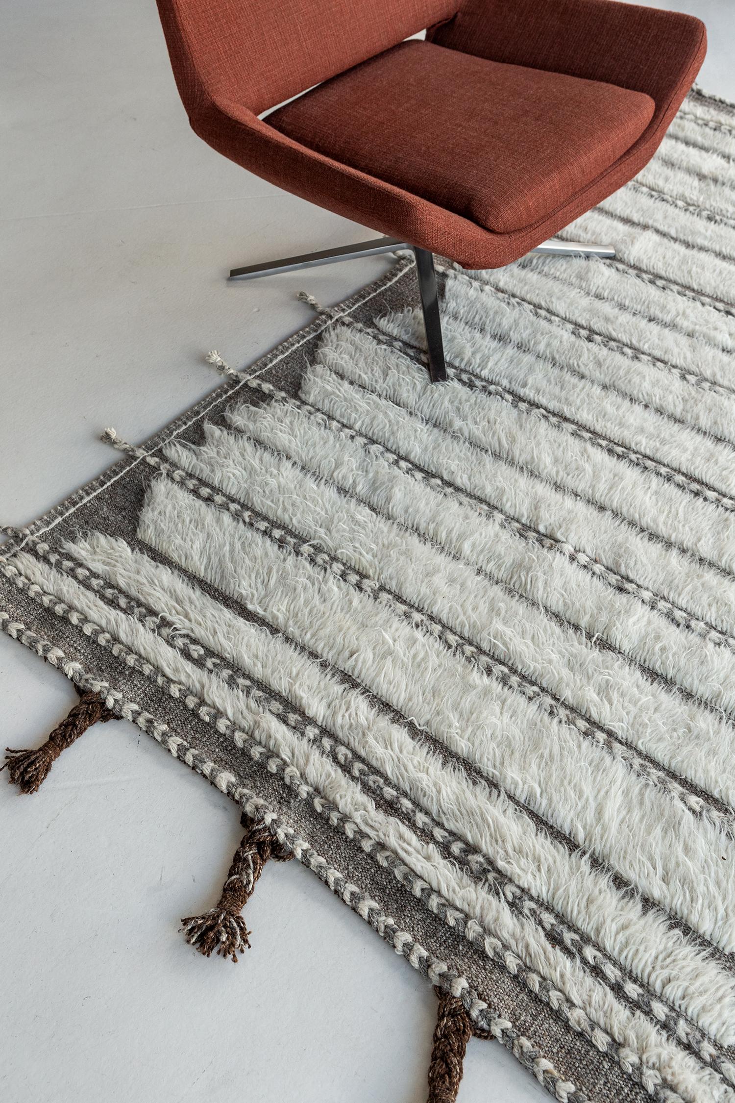 Abrolhos' is a handwoven luxurious wool rug with timeless embossed detailing. In addition to its perfect ivory flat weave, Albrohos has a beautiful shag that brings a lustrous texture and contemporary feel to one's space. The Haute Bohemian
