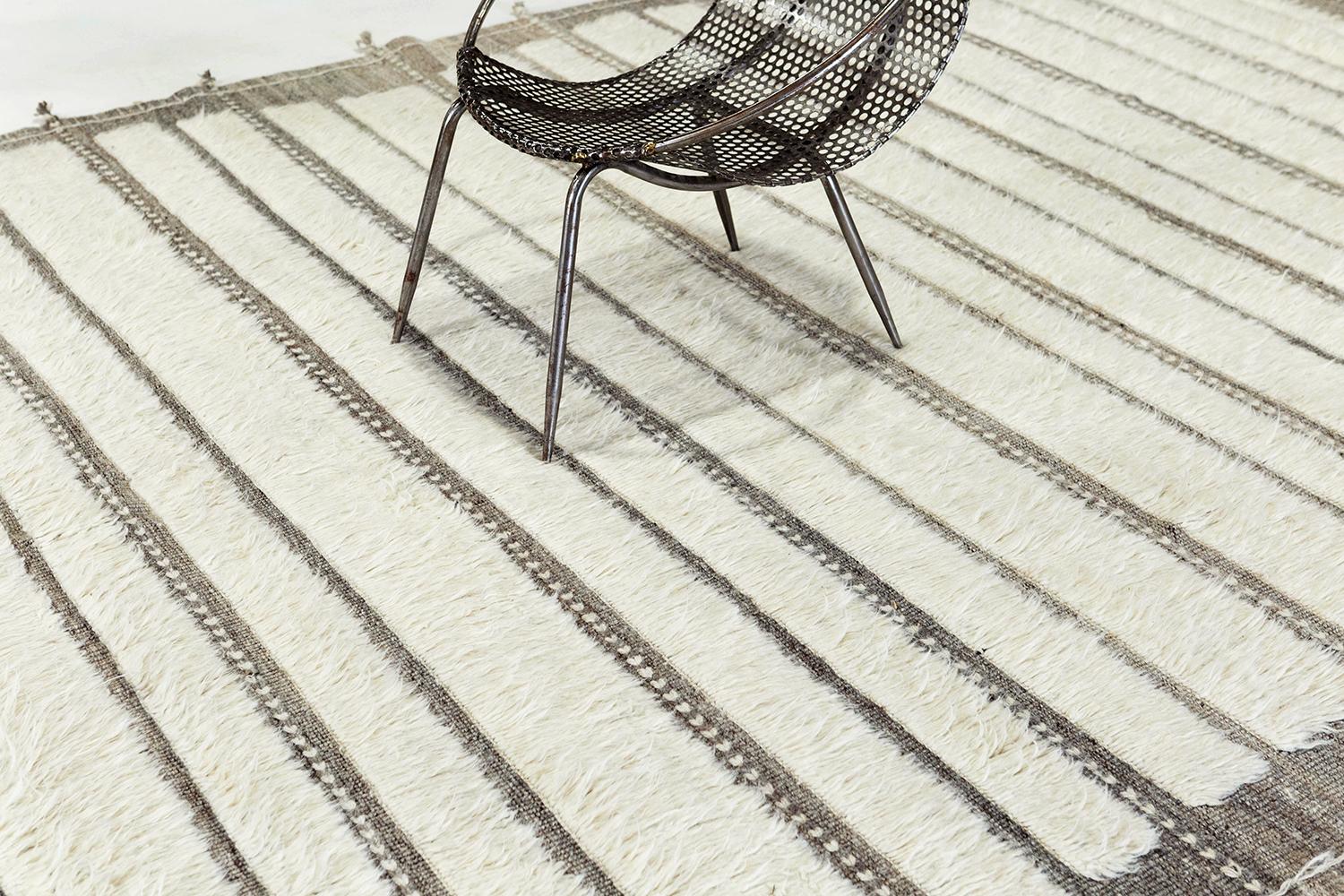 'Abrolhos' is a luxurious handwoven wool rug with timeless embossed detailing and detail braiding. In addition to its neutral earth-toned taupe flat weave, Shipca has a beautiful ivory shag that brings a lustrous and contemporary feel to one's