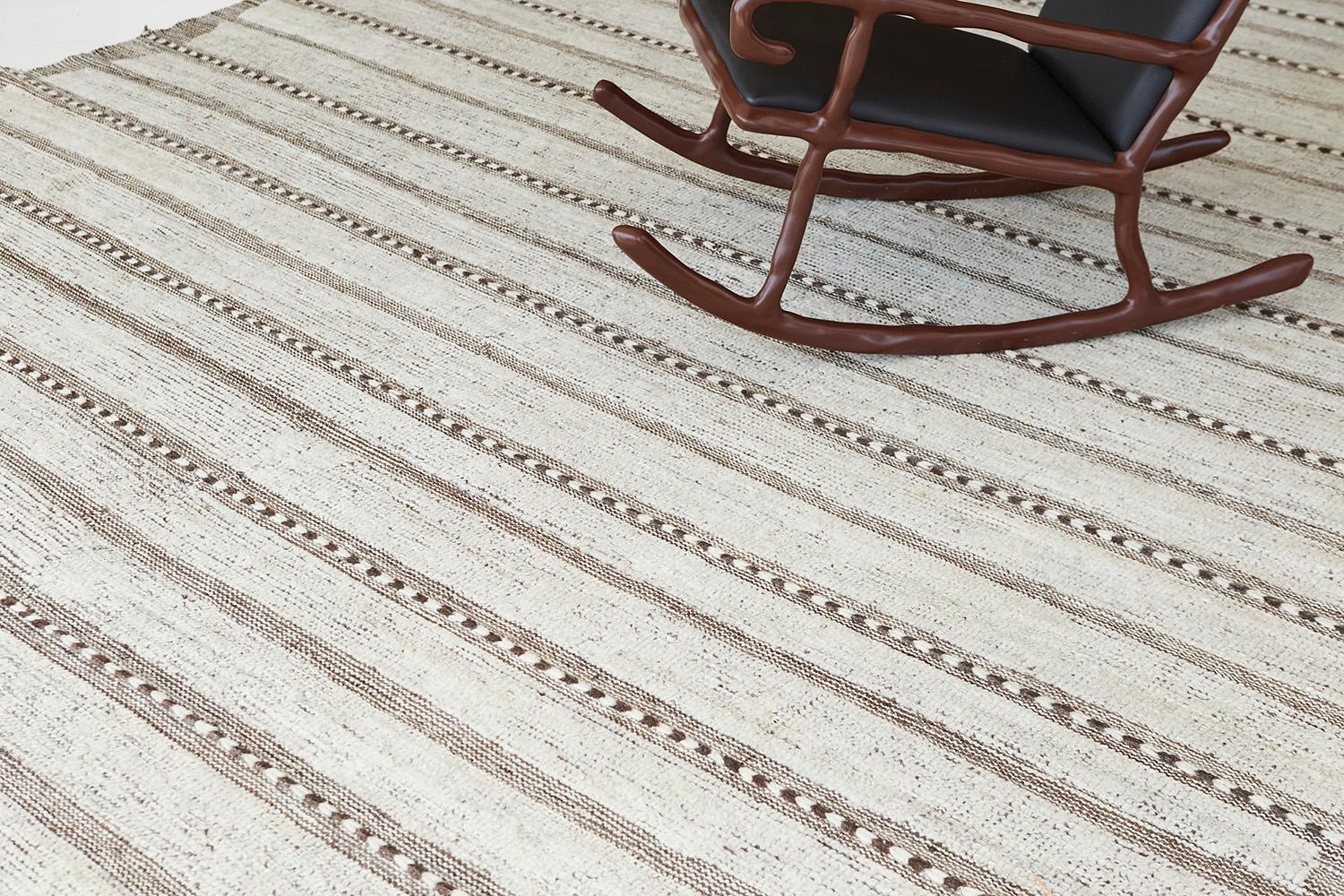 Abrolhos ist ein handgewebter, luxuriöser Wollteppich mit zeitlosen, geprägten Details. Zusätzlich zu seinem perfekten elfenbeinfarbenen Flachgewebe hat Albrohos einen schönen Shag, der eine glänzende Textur und ein modernes Gefühl in den Raum