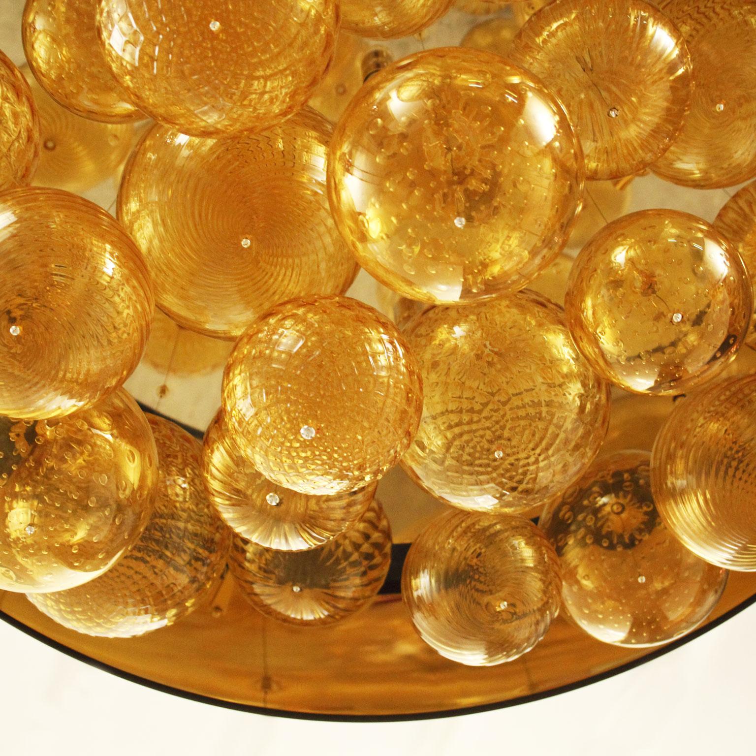Suspension absolue avec abat-jour en cotonette ivoire, éléments en verre artistique ambré. Cadre en or par Multiforme.
Collection éclectique, la lampe Absolute en verre soufflé est une œuvre d'éclairage qui peut être personnalisée de nombreuses