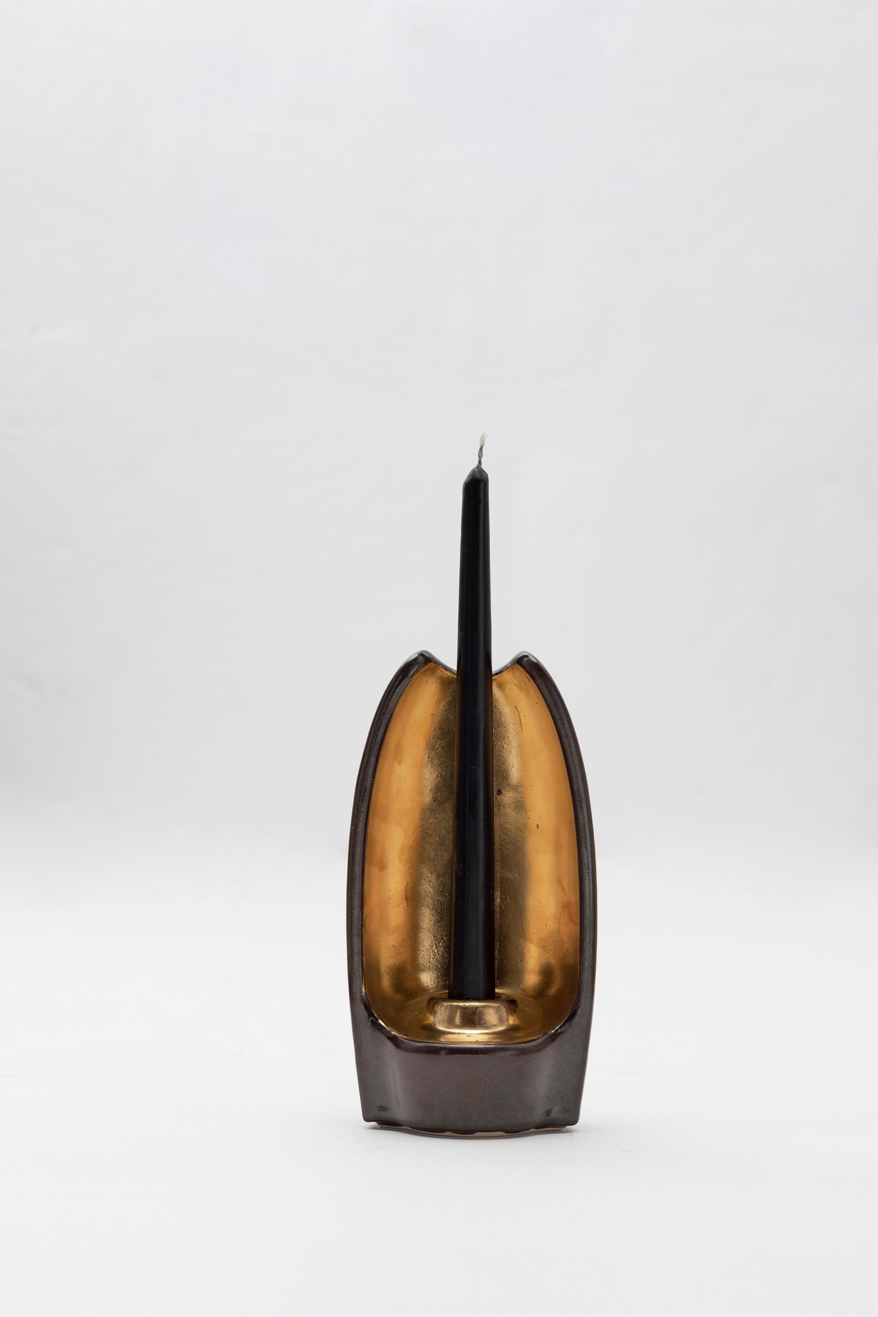 Portacandele decorativo in ceramica colata in scivolata, rifinito con un ricco smalto nero o verde scuro, evidenziato da dettagli dorati e candele di cera color avorio.

Un'esplorazione di El Absoluto (4000 - 1800 a.C.), un monolite di pietra