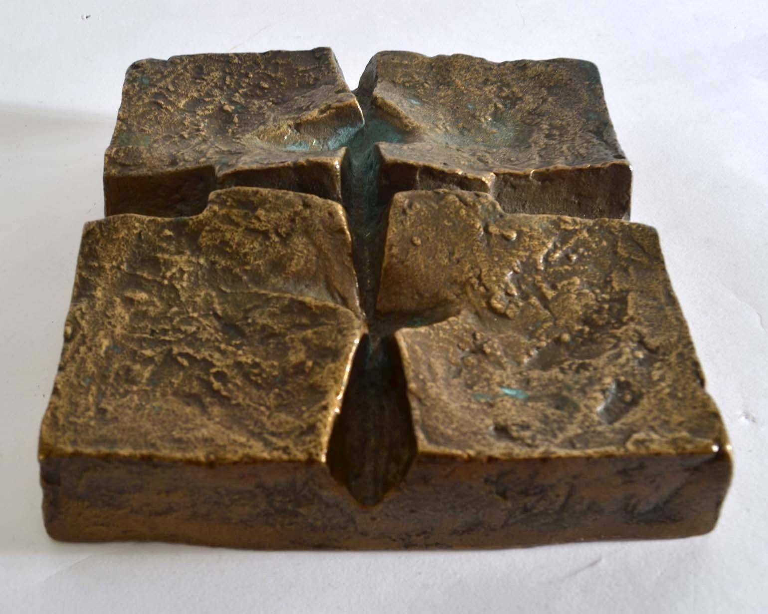 Brutalist 1970s bronze cast abstract relief if based on the cross form, raised in the areas of negative space around the cross and has a strong textural surface. 
It is ready to hang on the wall. It can also be used and works well as a table