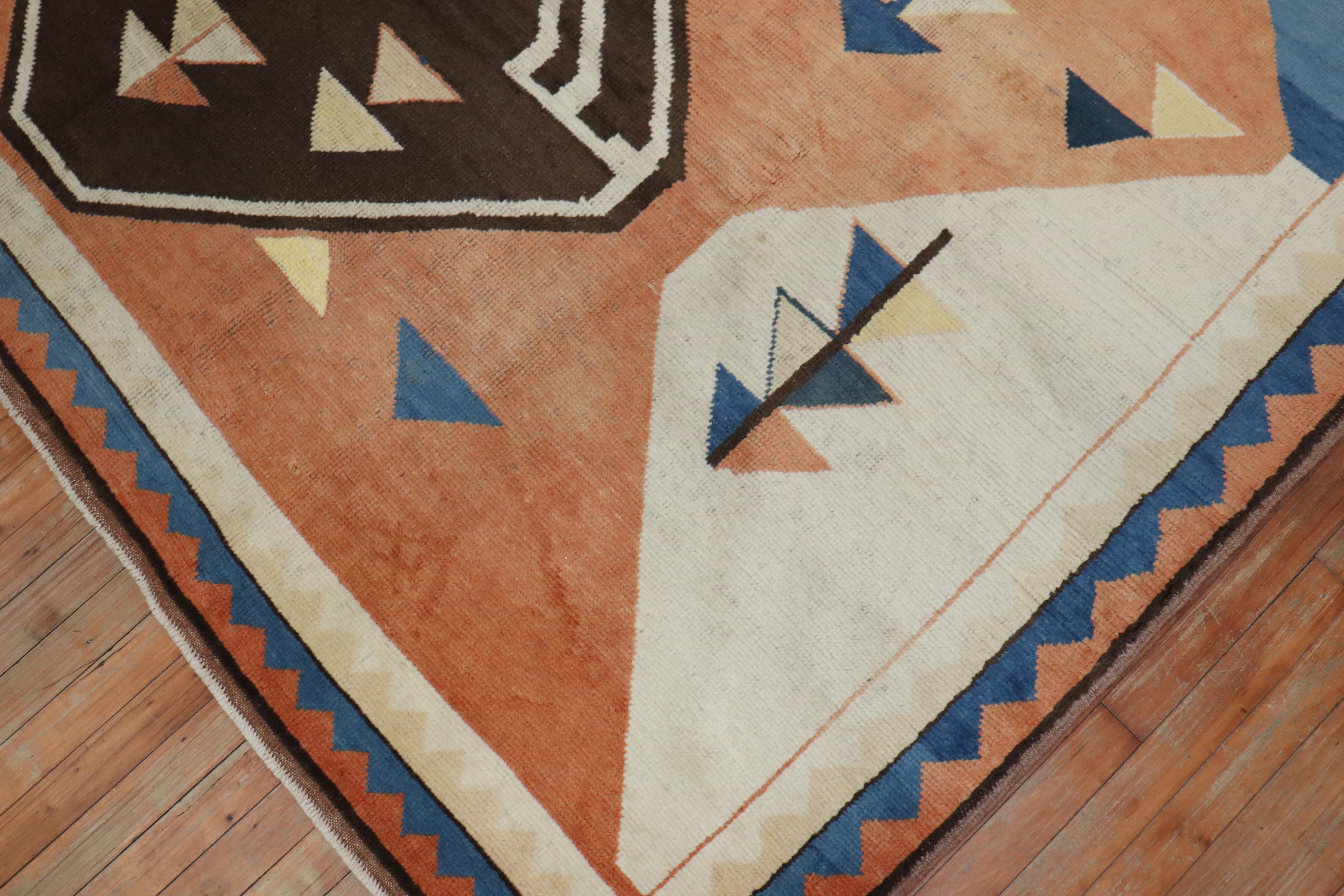 A one of a kind mid-20th century primitive and abstract Turkish deco rug inspired by rugs from the gabbeh tribe in Northwest Persian. Large scale bold geometric medallions hover over a peach ground. Blue, brown and ivory accents,

circa third