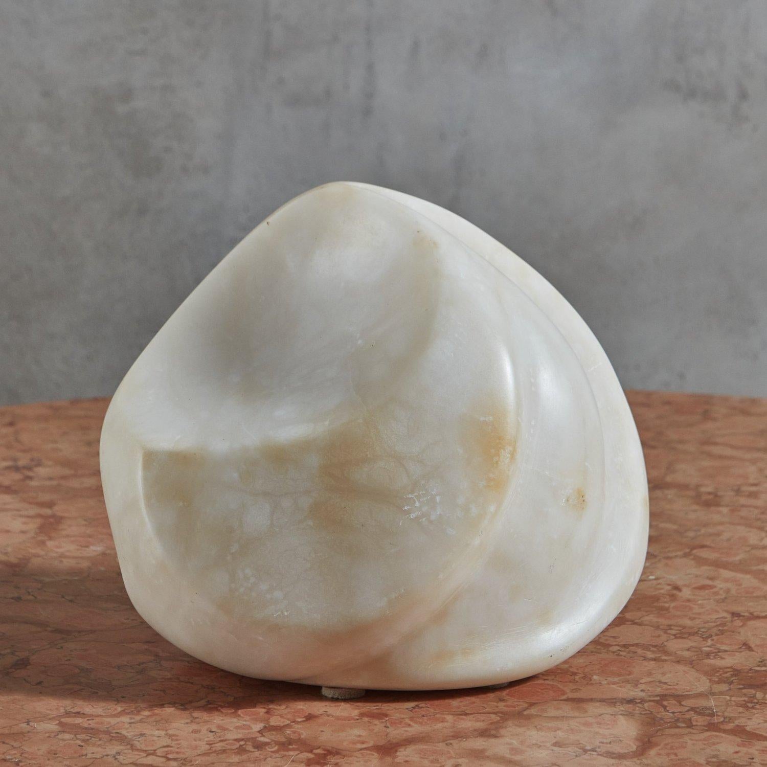 A vintage abstract sculpture hand carved from a gorgeous alabaster stone. This piece features elegant curves and subtle cream, white and taupe veining. Engraved ‘SS84’ on base. 20th Century.