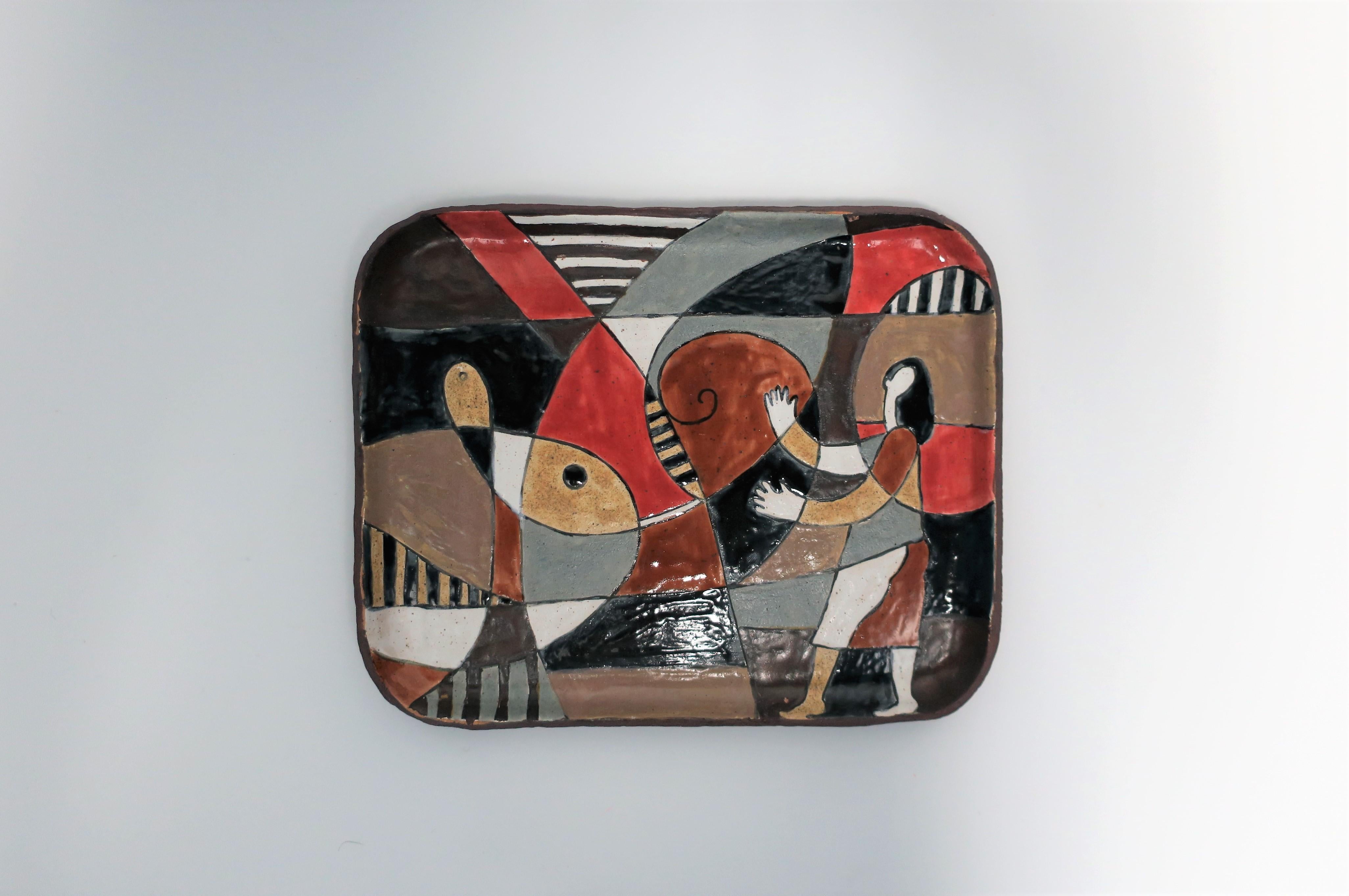 A very beautiful pottery artwork tray with abstract and figural design. Colors include black, white, red/burgundy/ox blood, grey, tan, and brown. Matte underside, please see image #9. A beautiful piece for a wall, table, vanity, or other. 

Piece