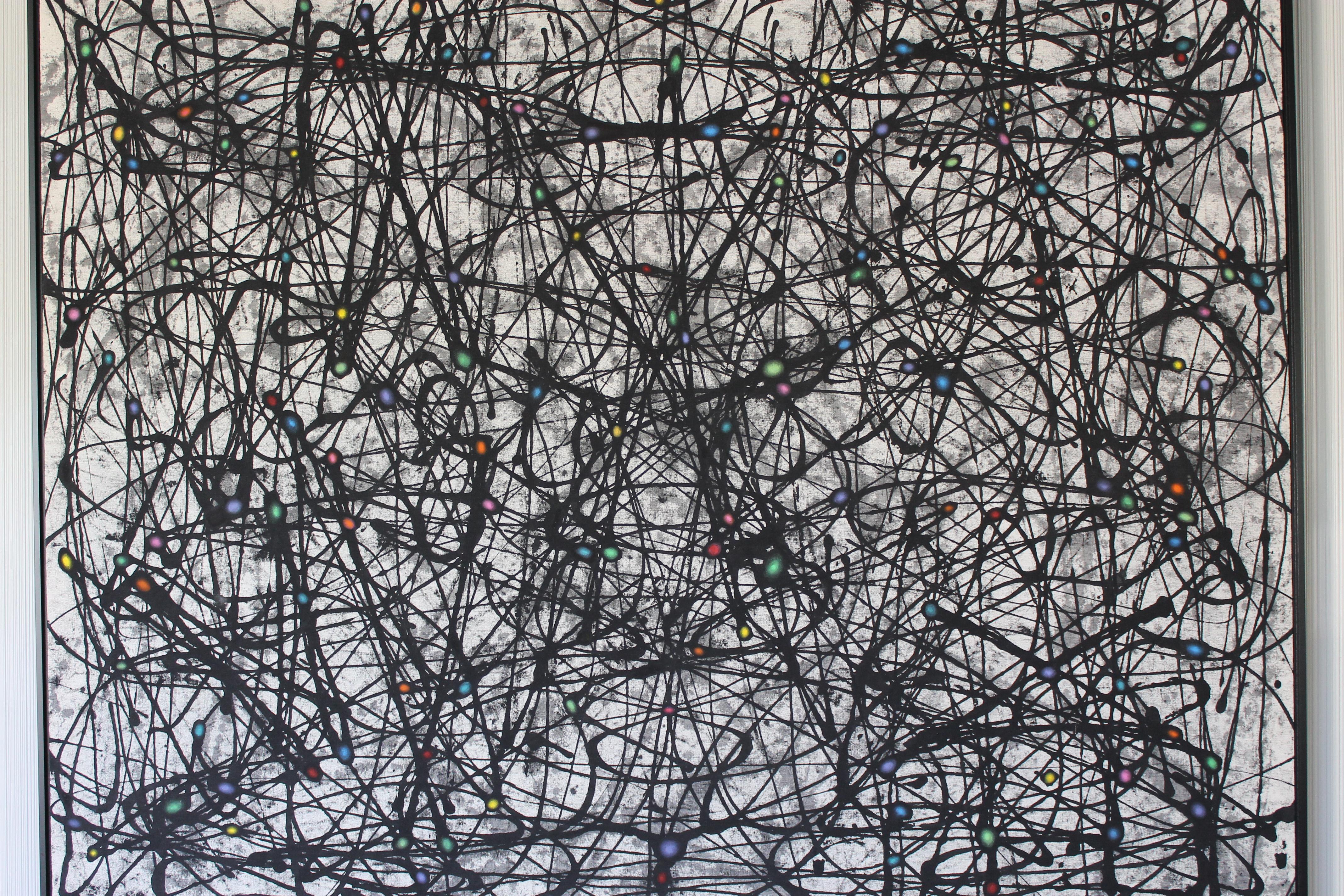 A large abstract acrylic action painting on raw canvas, black and grey drizzles with different colored spots at the intersections, creating an atomic proton/neutron feel. Surely a nod to Jackson Pollock's mid century abstract paintings. Newly framed
