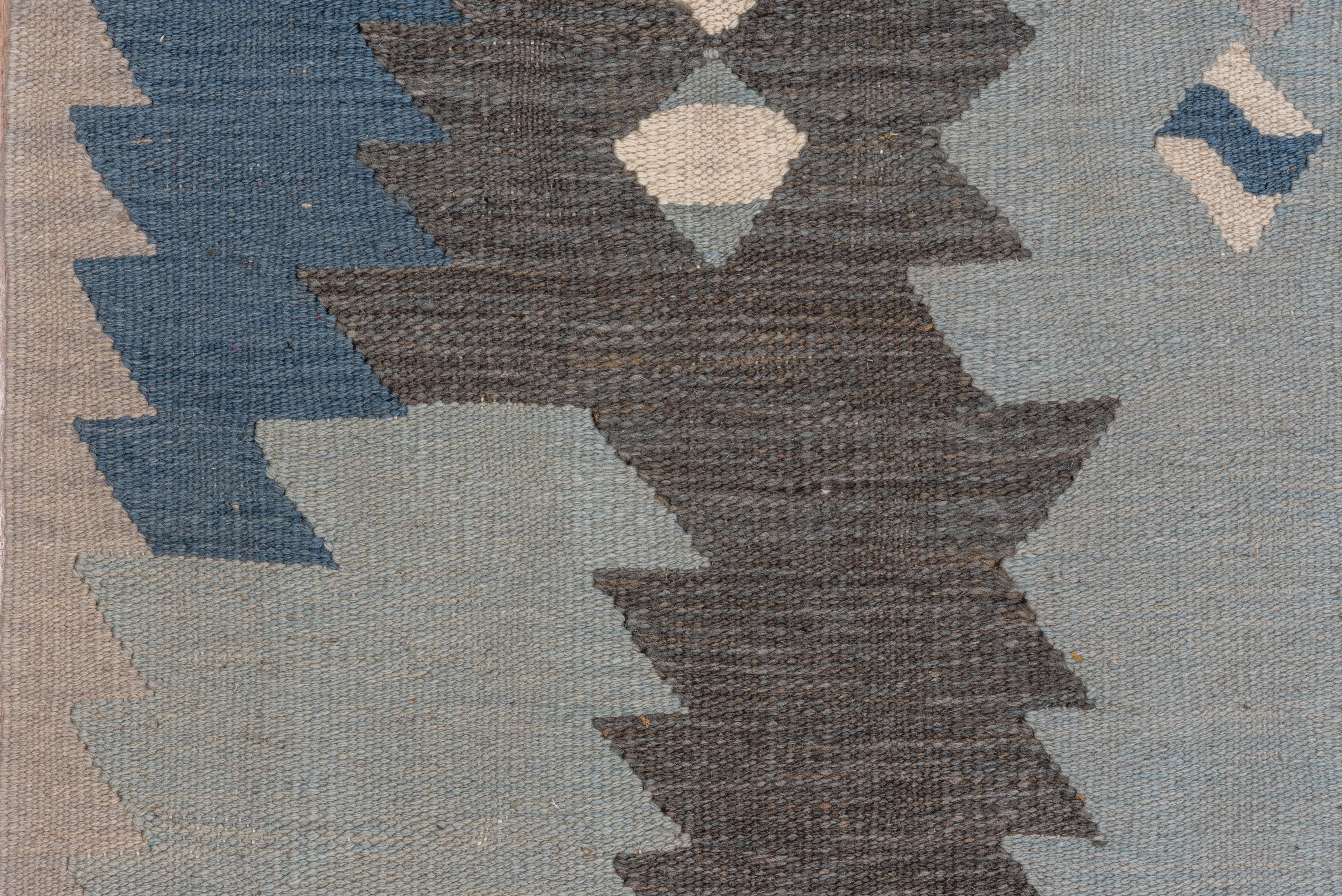 A palette featuring a range of mellow blues and touches of gray Slit tapestry weave, wool pattern wefts. More tonally bold, but with a pattern of diminutive lozenges and dominating sawtooth motives. Narrow triangle zig-zag border. As new condition.