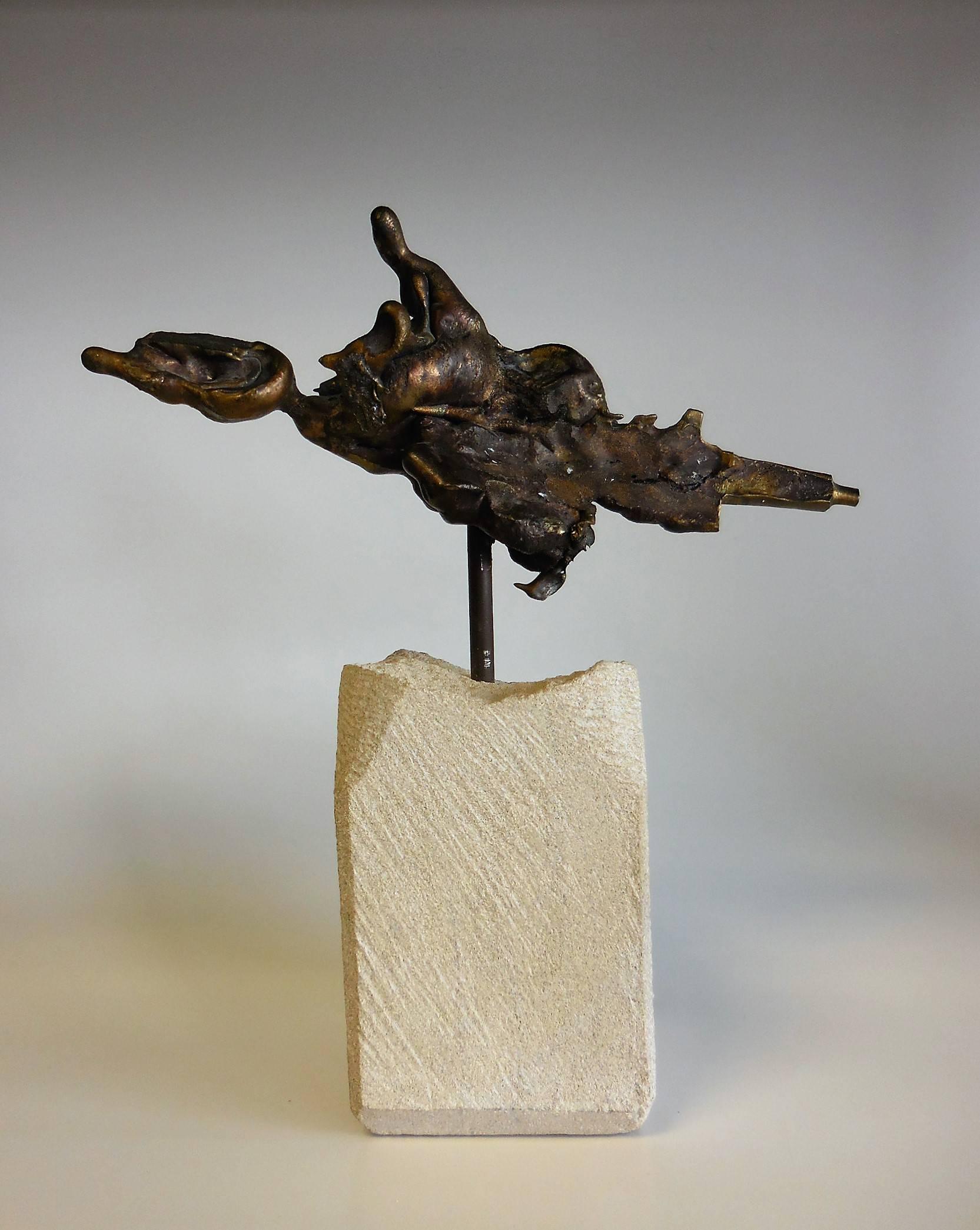 An abstract bronze sculpture mounted on a stone base.