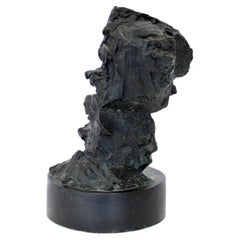 Escultura abstracta de bronce que recuerda a las rocas que surgen de forma natural