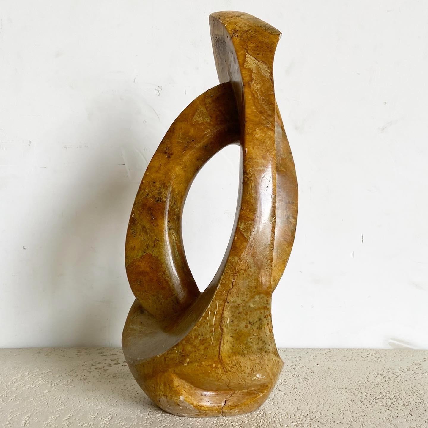 Introduisez une touche de sophistication artistique avec cette sculpture abstraite en pierre brune. Son jeu unique de formes et d'ombres en fait non seulement un point focal étonnant, mais aussi un sujet d'interprétation, enrichissant tout espace