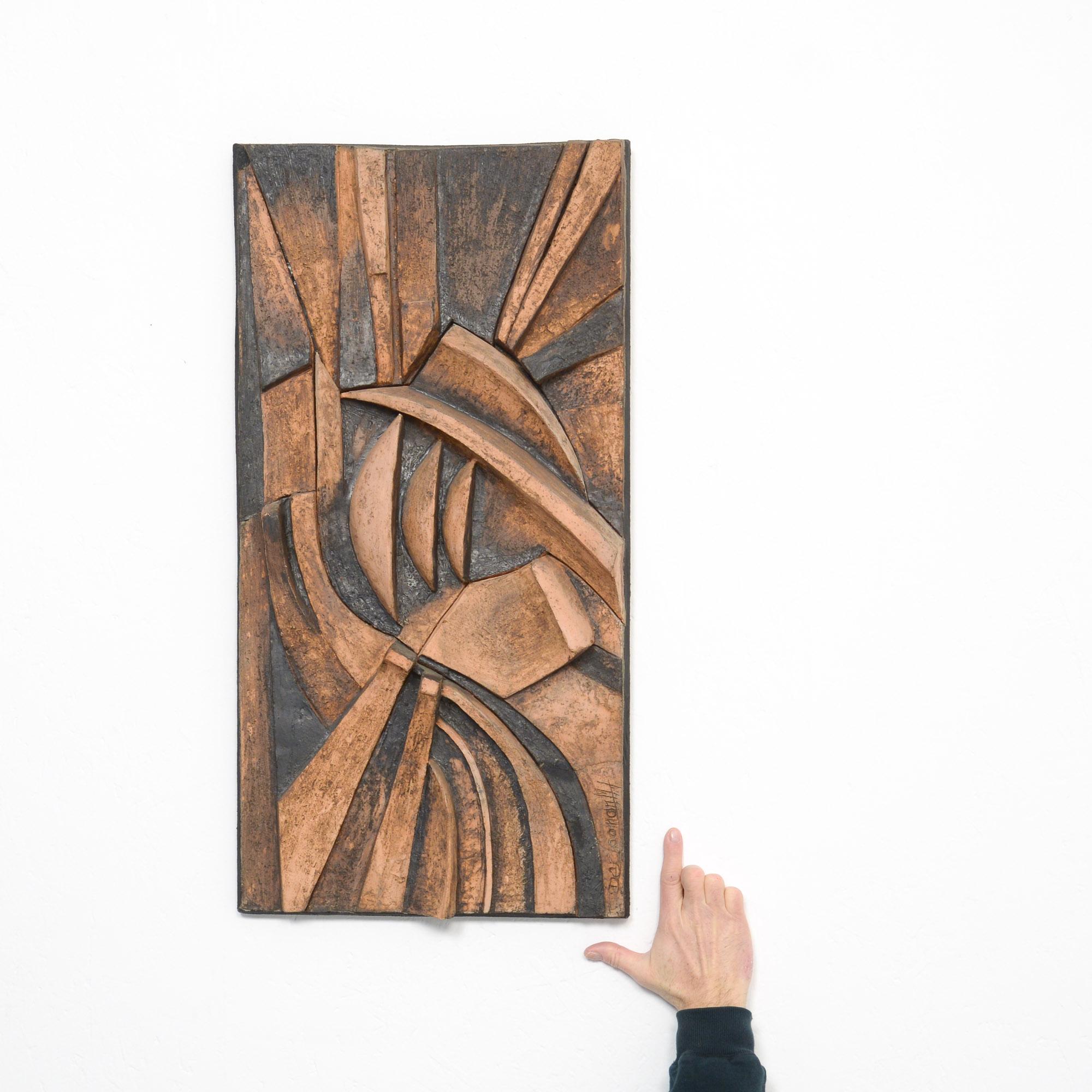 This abstract ceramic wall sculpture can be dated in the 1970s. It was made by the Belgian artist M. De Cooman.
It is a dynamic work made of natural and black colored ceramic.
The simple geometric design patterns are in bas-relief.
This wall