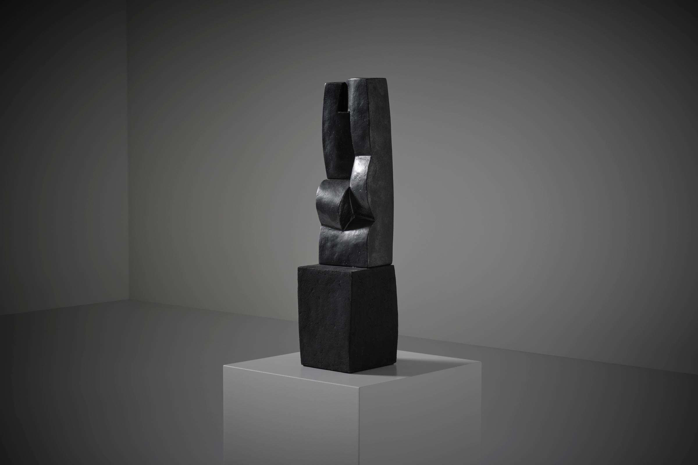 Unique Ceramic sculpture by Cor Dam (1935 -2019), the Netherlands 1970s. Beautiful abstract work showing strong interlocking cubistic shapes, finished in a glossy anthracite enamel. The irregular cubic 'base' is part of the sculpture and is finished