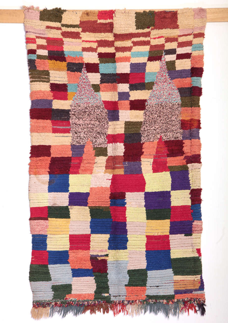 An unusual Berber rug decorated by an abstract chequerboard pattern in contrasting colours and by a pair of dome-shaped elements in the 'salt-and-pepper' technique. The pile is composed of different materials, ranging from natural materials such as