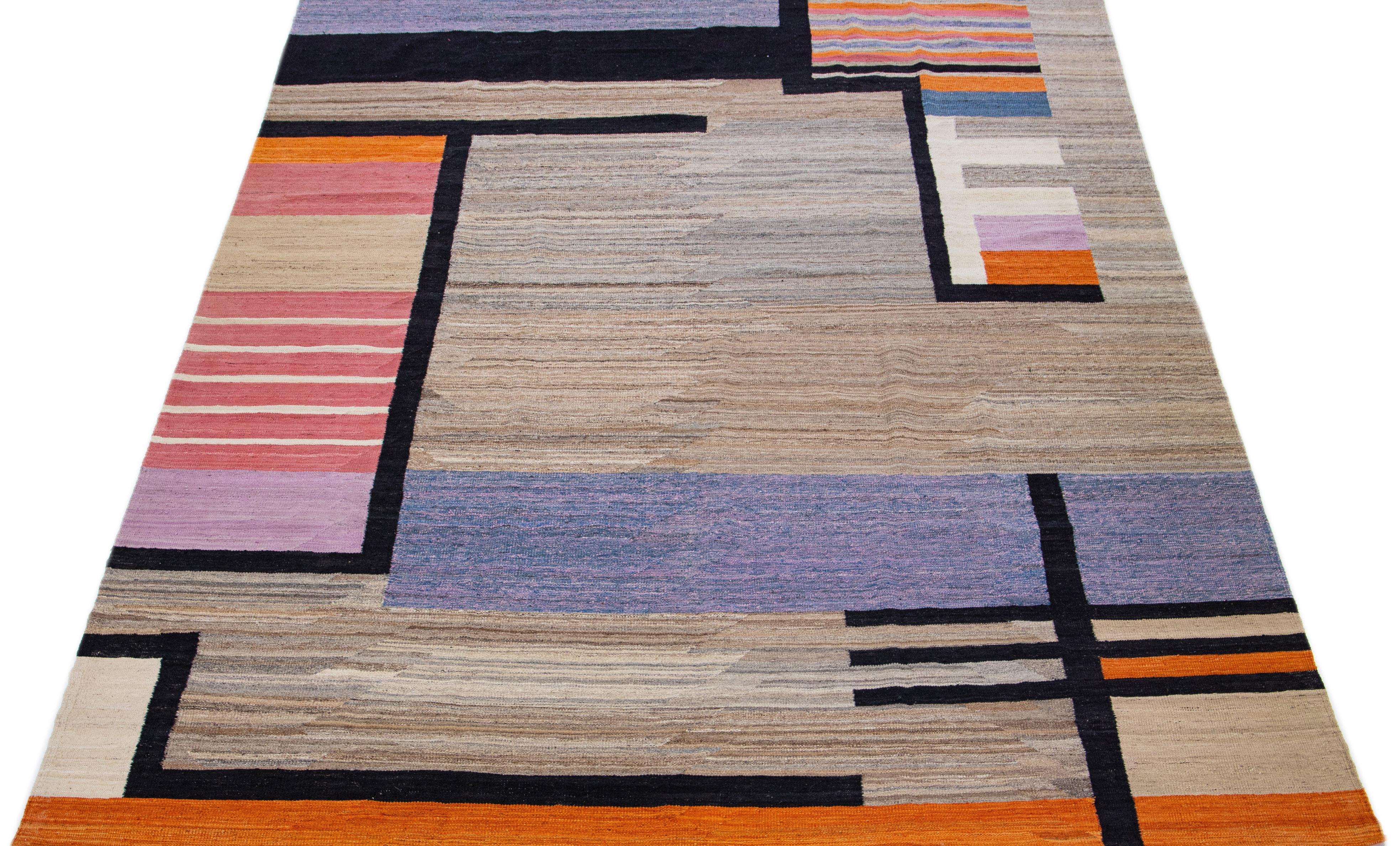 This Deco flatweave wool rug exhibits a captivating brown field with orange, black, and purple accents, creating a contemporary and aesthetically-pleasing effect. Its intricate, vibrant design combines to create a modern centerpiece that will add