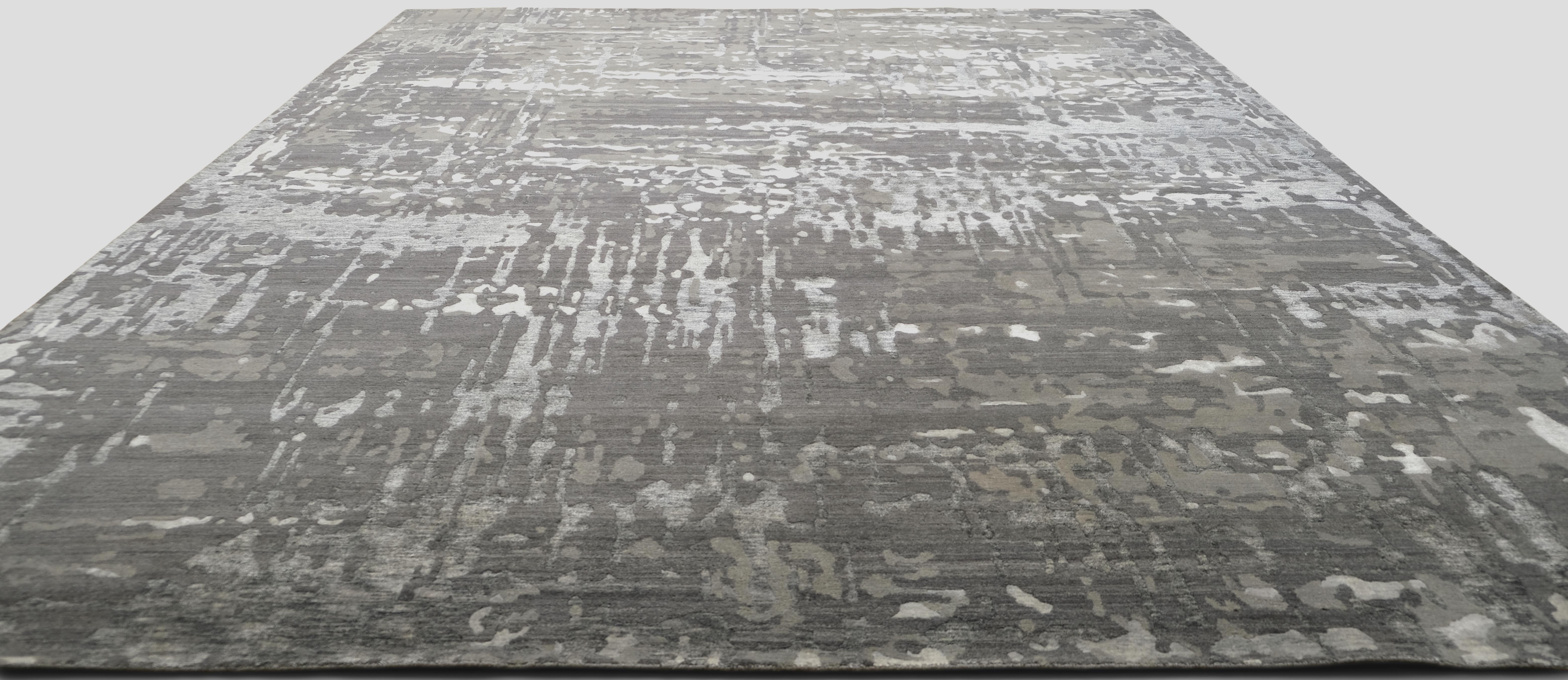 Dieser exquisite, handgeknüpfte Teppich aus Wolle und Bambus-Seide mit seinem raffinierten, abstrakten Muster in Grau- und Blaugrautönen verleiht Ihrem Interieur eine besondere Note. Das moderne, strukturierte Muster strahlt Tiefe und Dimension aus