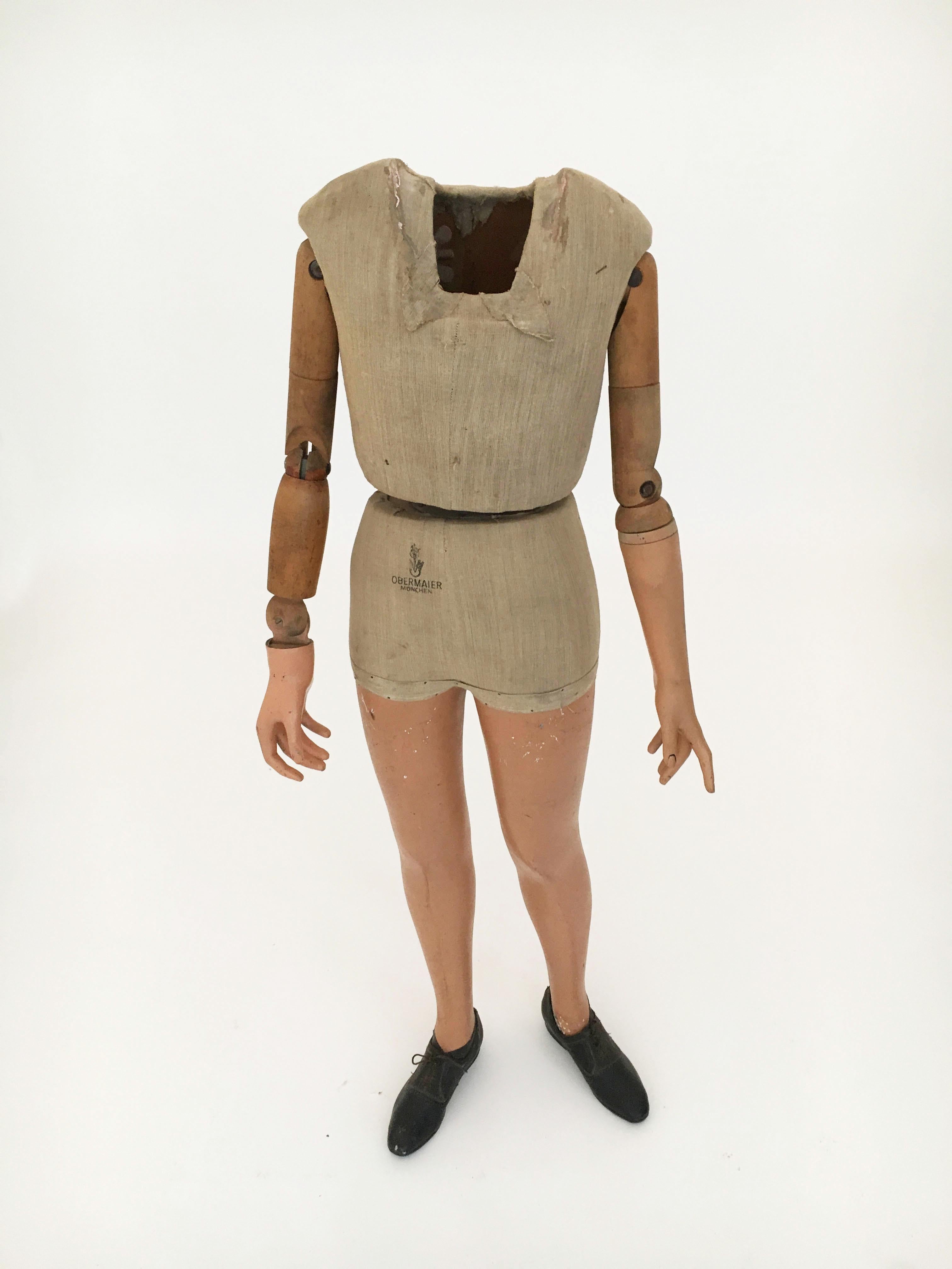 A fine tall boys torso German store mannequin, circa 1930s with moveable arms. The muslin covered body was used to display clothing in a shopfront window. Today we very much envision this as a modern piece of abstract DADA art piece. Or simply a
