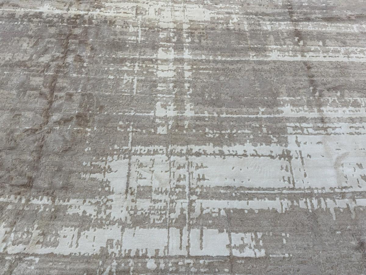 A stunning abstract area rug that is lovely to behold and soft underfoot. Dominant tones are beige, taupe and cream. A wool/viscose blend gives it durability with softness and sheen. Handmade and Handknotted in India.